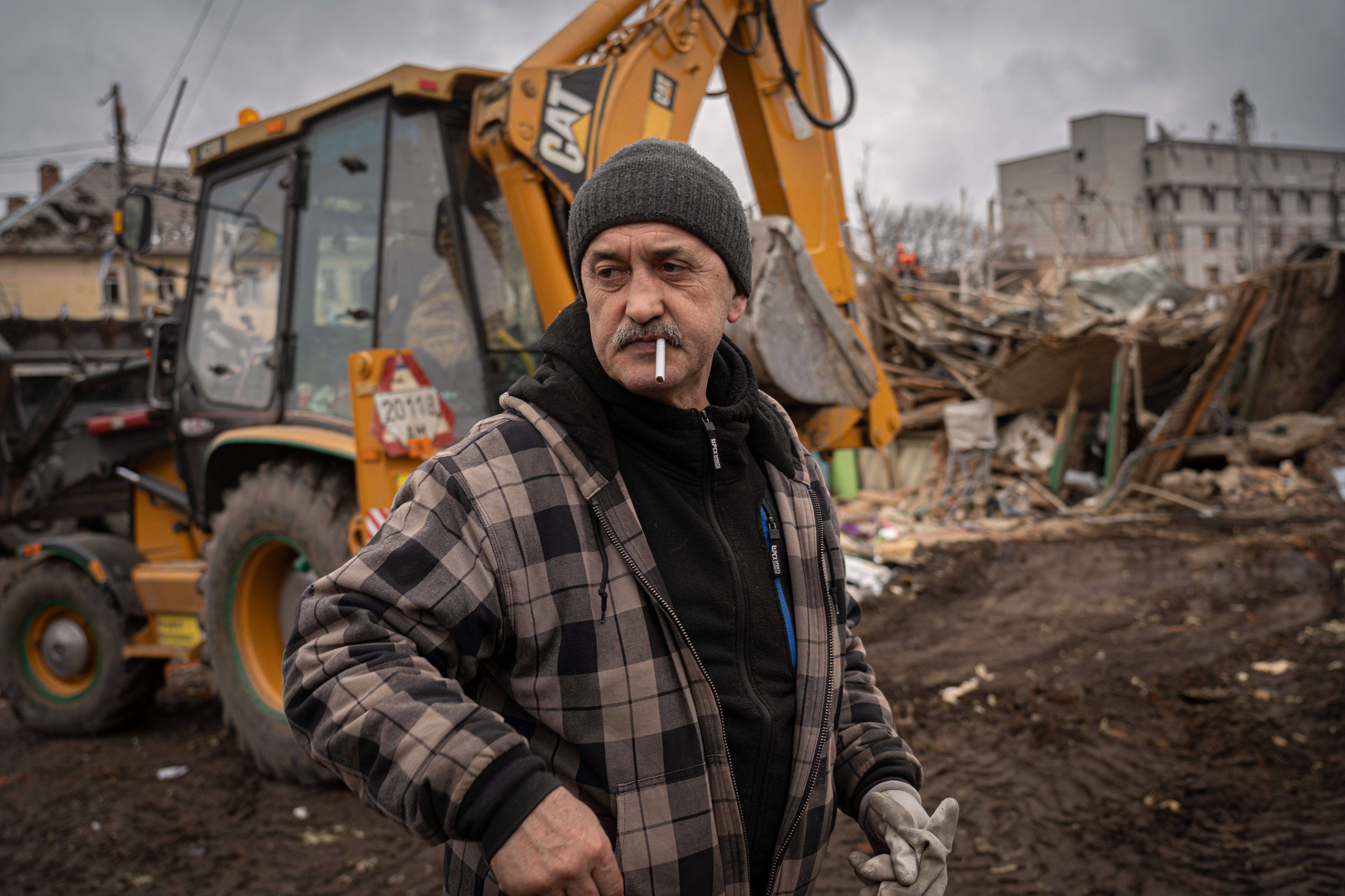 Pavel stands next to the remains of his destroyed home