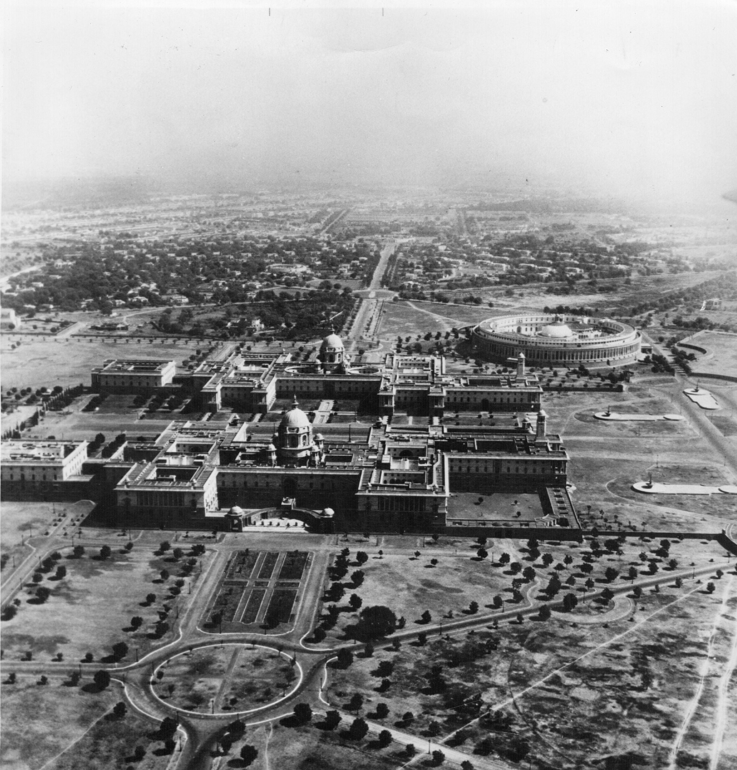 An aerial view of the government buildings of New Delhi, circa 1930, showing expanses of open space and gardens surrounding the buildings