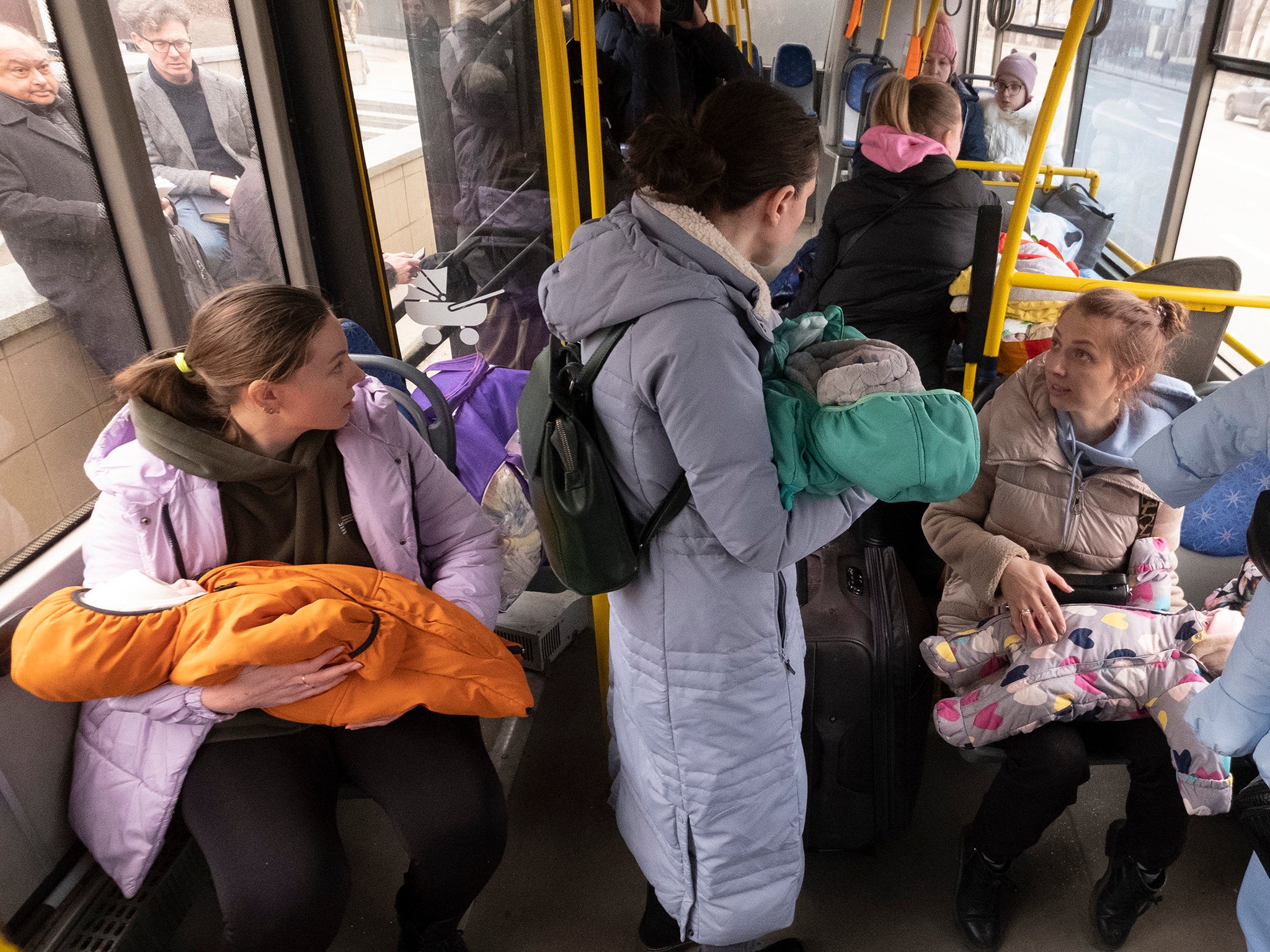 Mothers, babies and other patients are loaded aboard a bus from the Central Children’s Hospital in Kyiv for evacuation