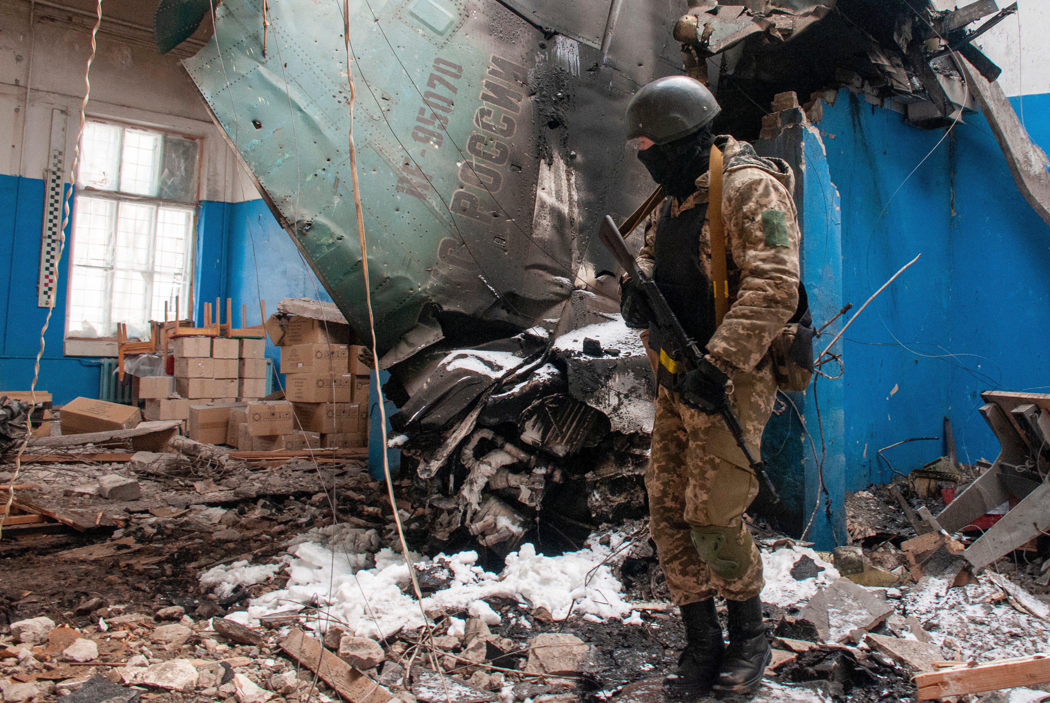 A Ukrainian serviceman looks on the debris of Russian fighter-bomber aircraft Su-34 in Kharkiv