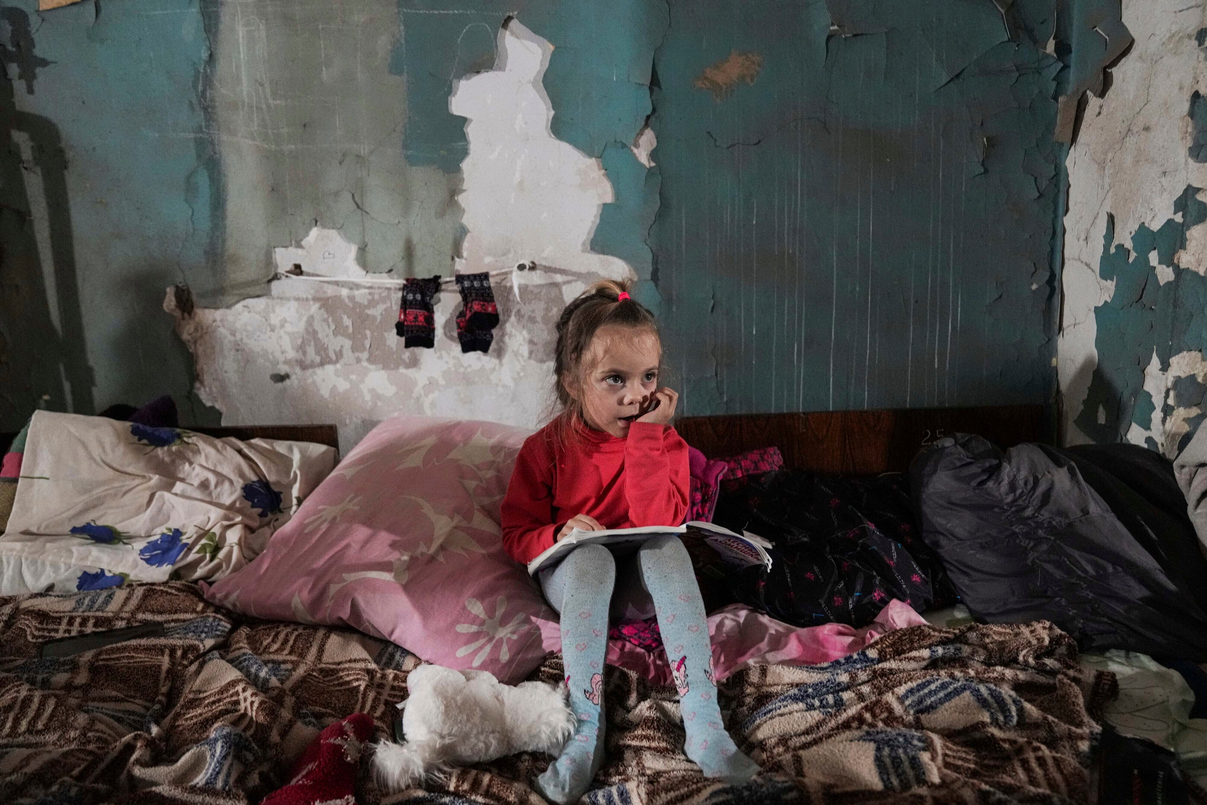 A Ukrainian girl sits in the improvised bomb shelter in Mariupol