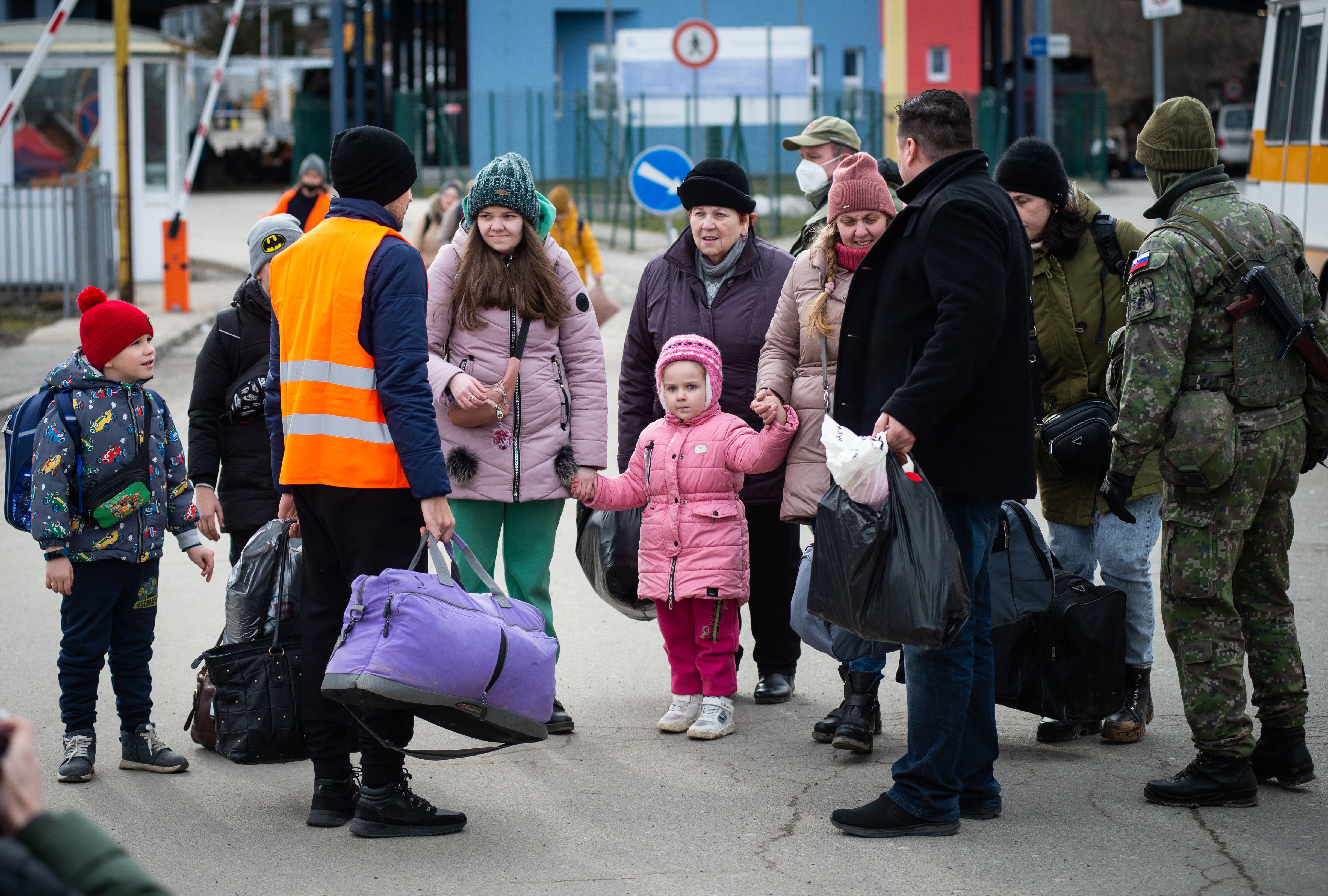 Slovak soldiers and volunteers help Ukrainian refugees after they crossed the border in Vysne Nemecke, eastern Slovakia, 26 February 2022