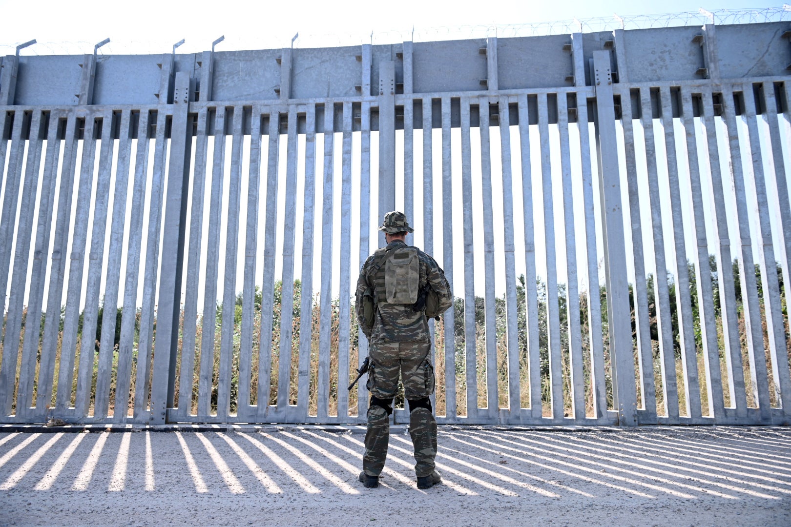 File photo: A soldier stands in front of a steel fence built along the Evros River in the area of Feres, at the Greek-Turkish border, Greece, 1 September 2021