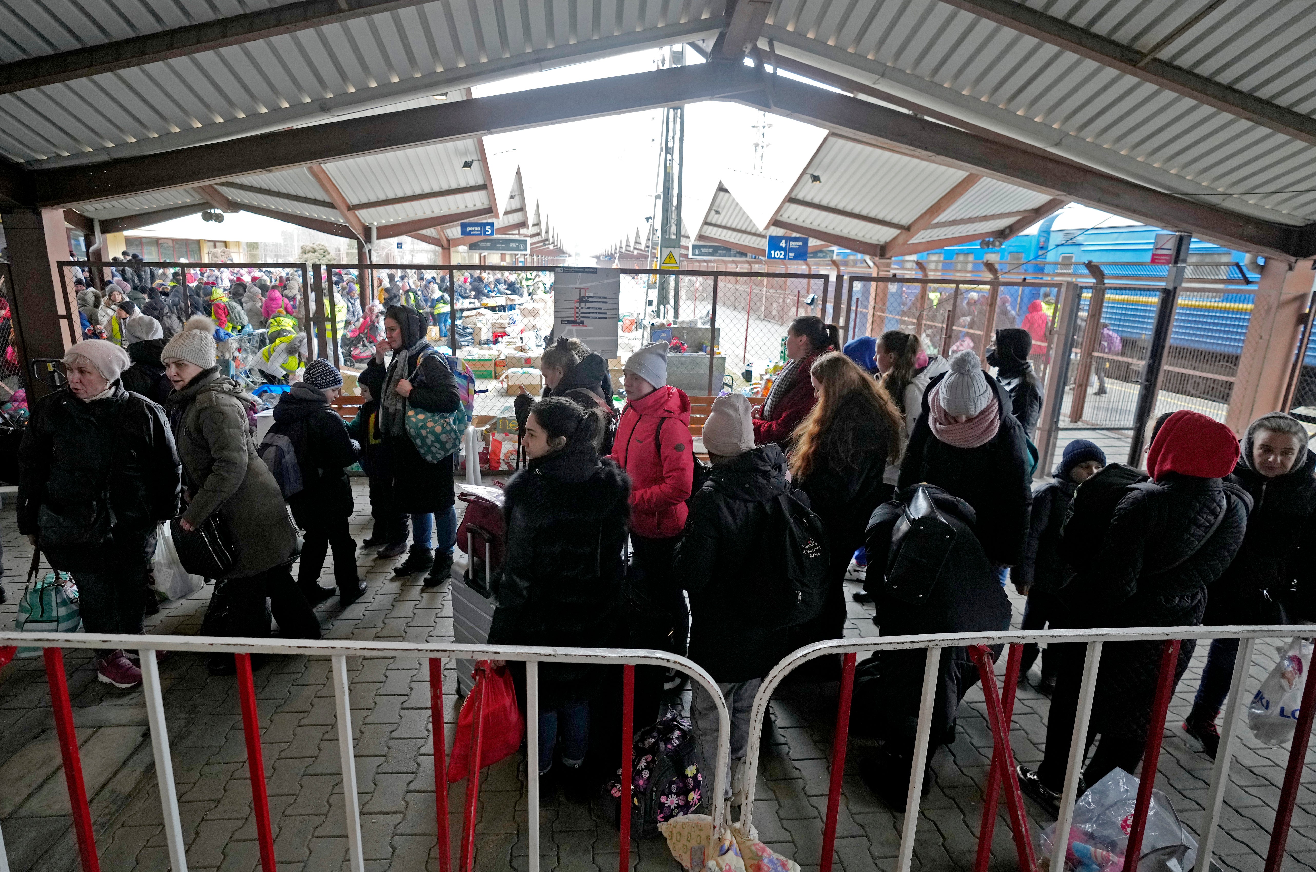 People stand in a line as they arrive on a train from Odesa, Ukraine, at the station in Przemysl, Poland