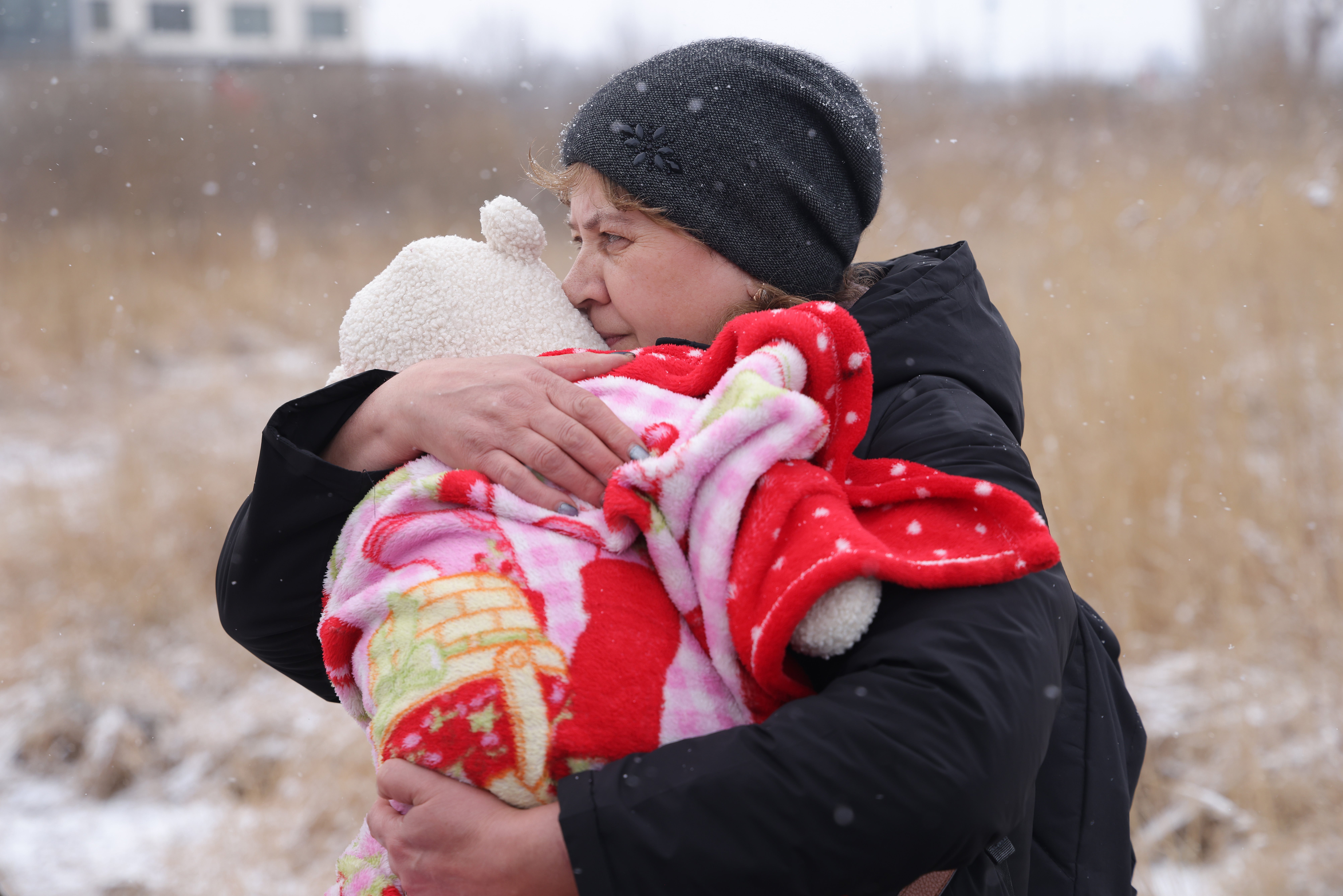 Natasha Sivek carries her 2-month-old grandson Meron shortly after she and other family members, including her daughter, walked into Poland from war-torn Ukraine