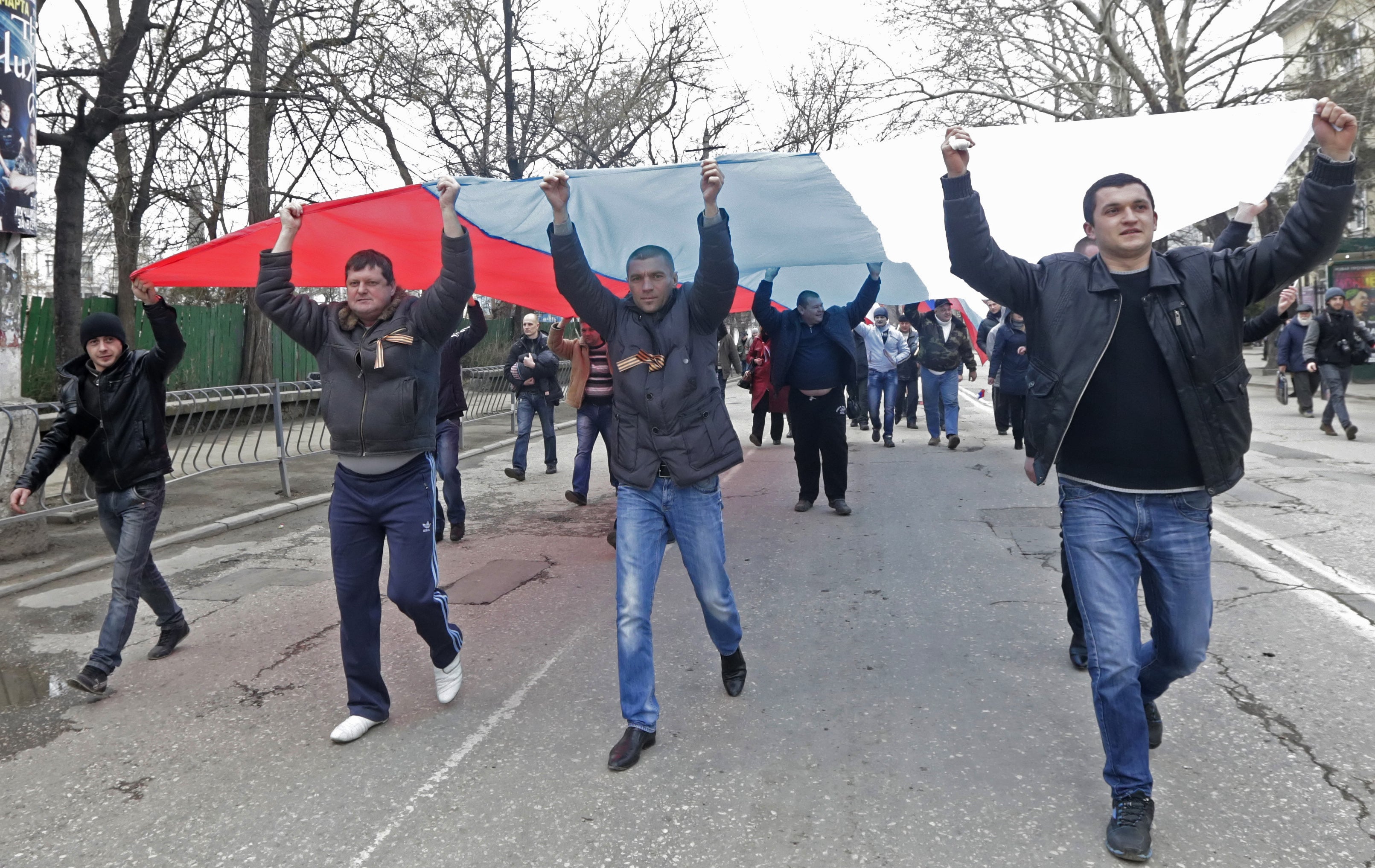 A group of pro-Kremlin activists walk with huge Russian flags in Simferopol in Crimea, Ukraine, 1 March 2014