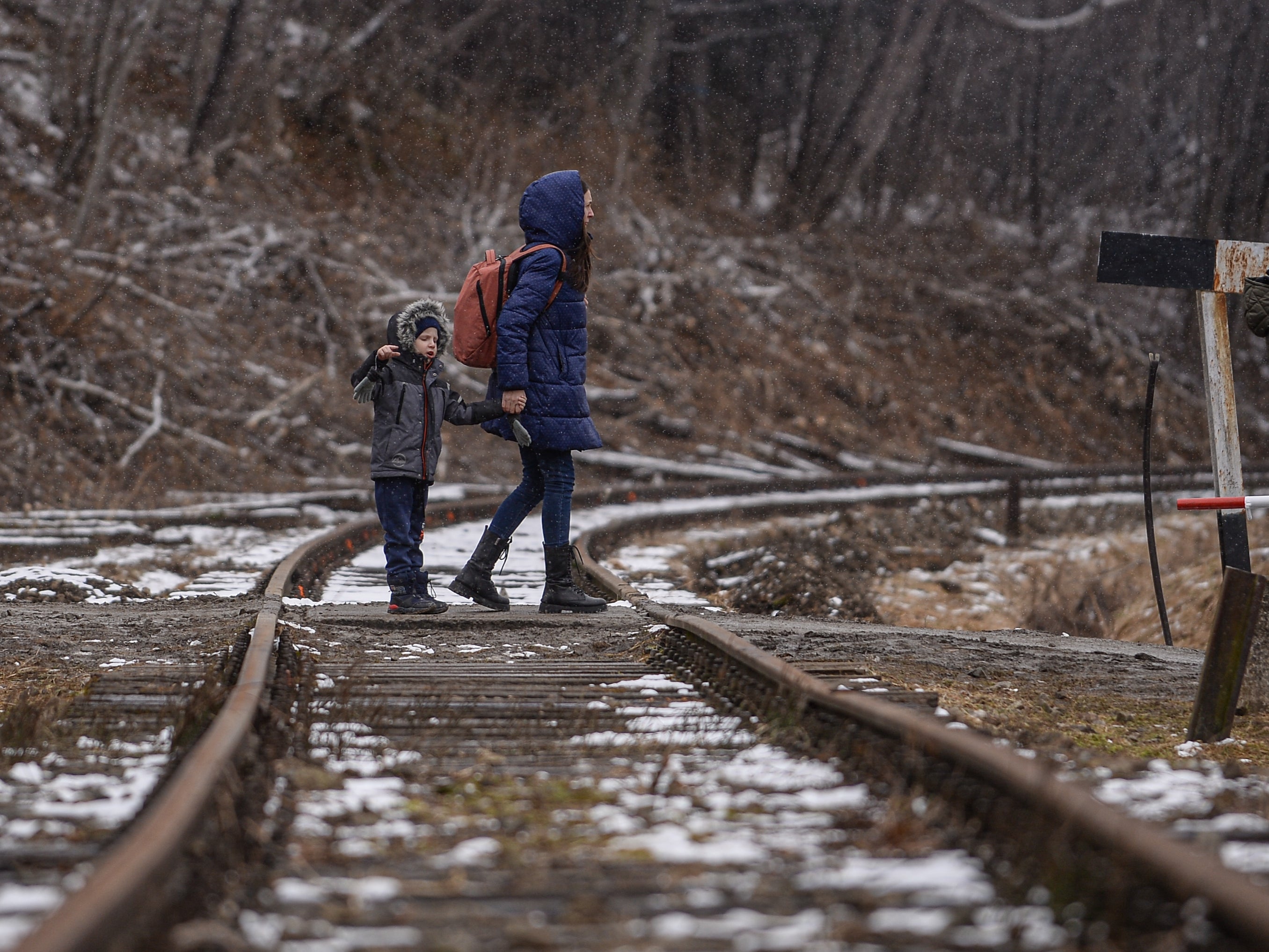 A woman and child who fled the war walk to a bus to be relocated across Poland after crossing the Polish Ukrainian border