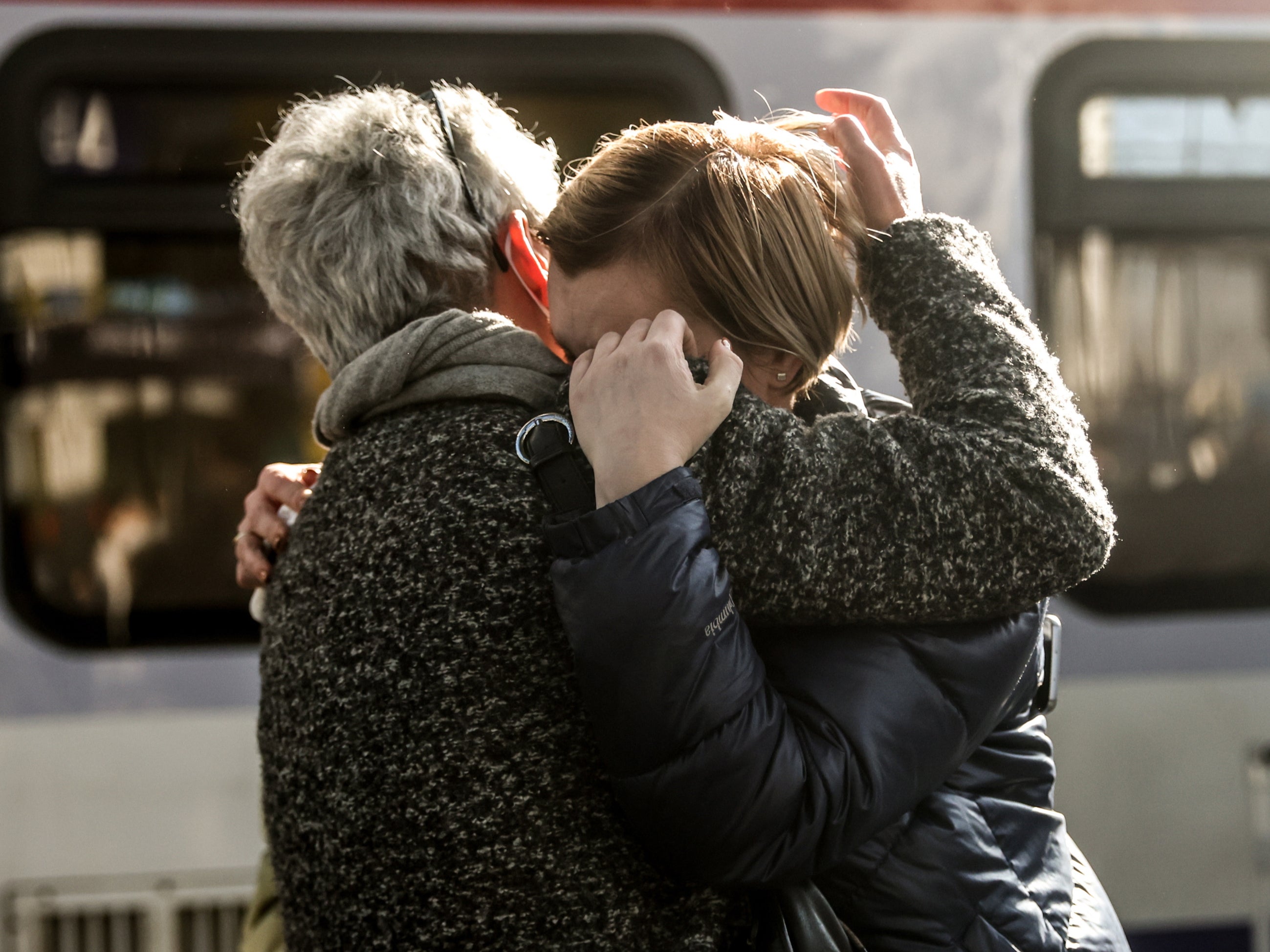 Two women hug as Ukrainian refugees arrive from Poland at Berlin central station