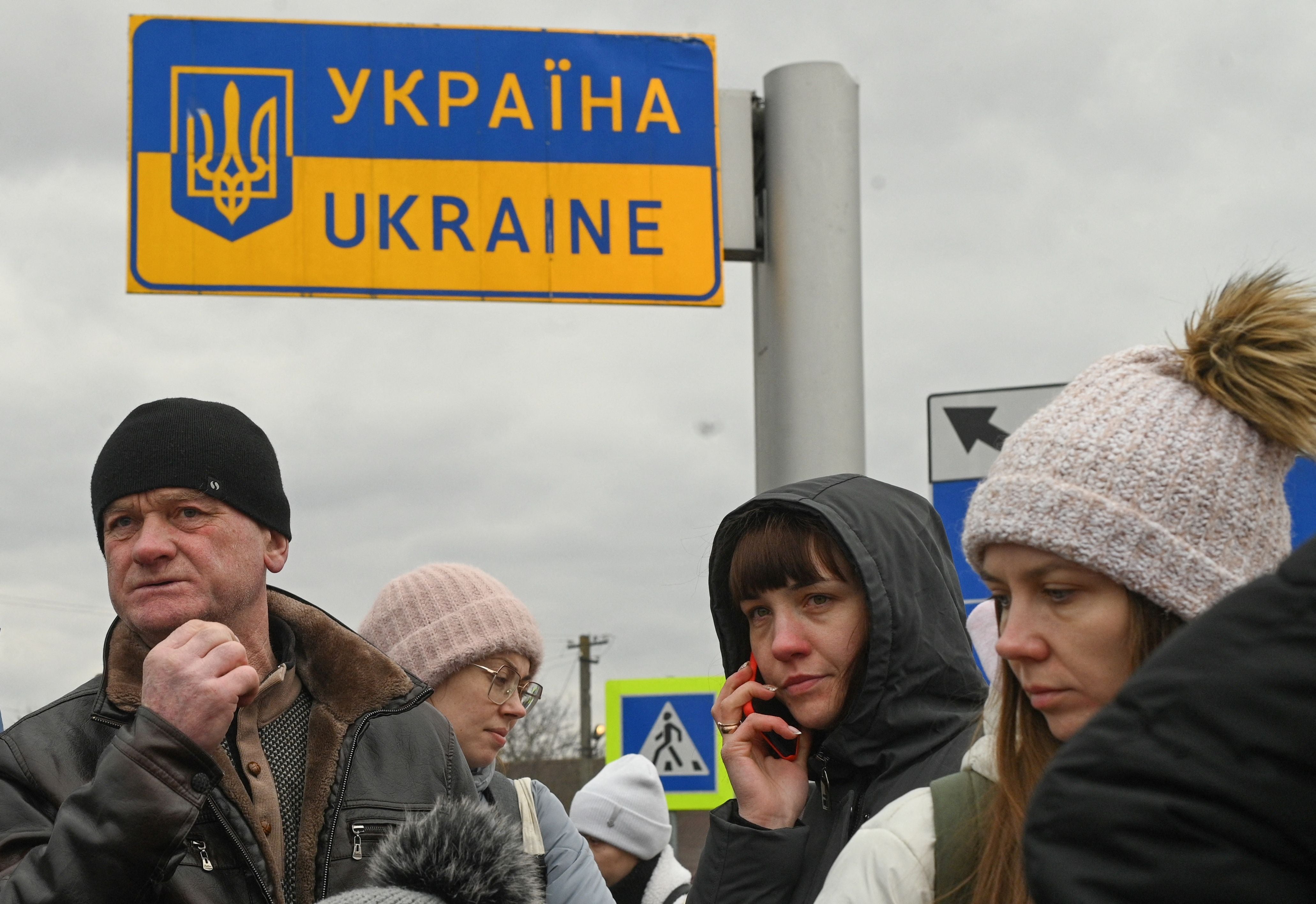 Ukrainian refugees wait on the line near the border with Poland at the town of Ustyluh, western Ukraine on March 6, 2022