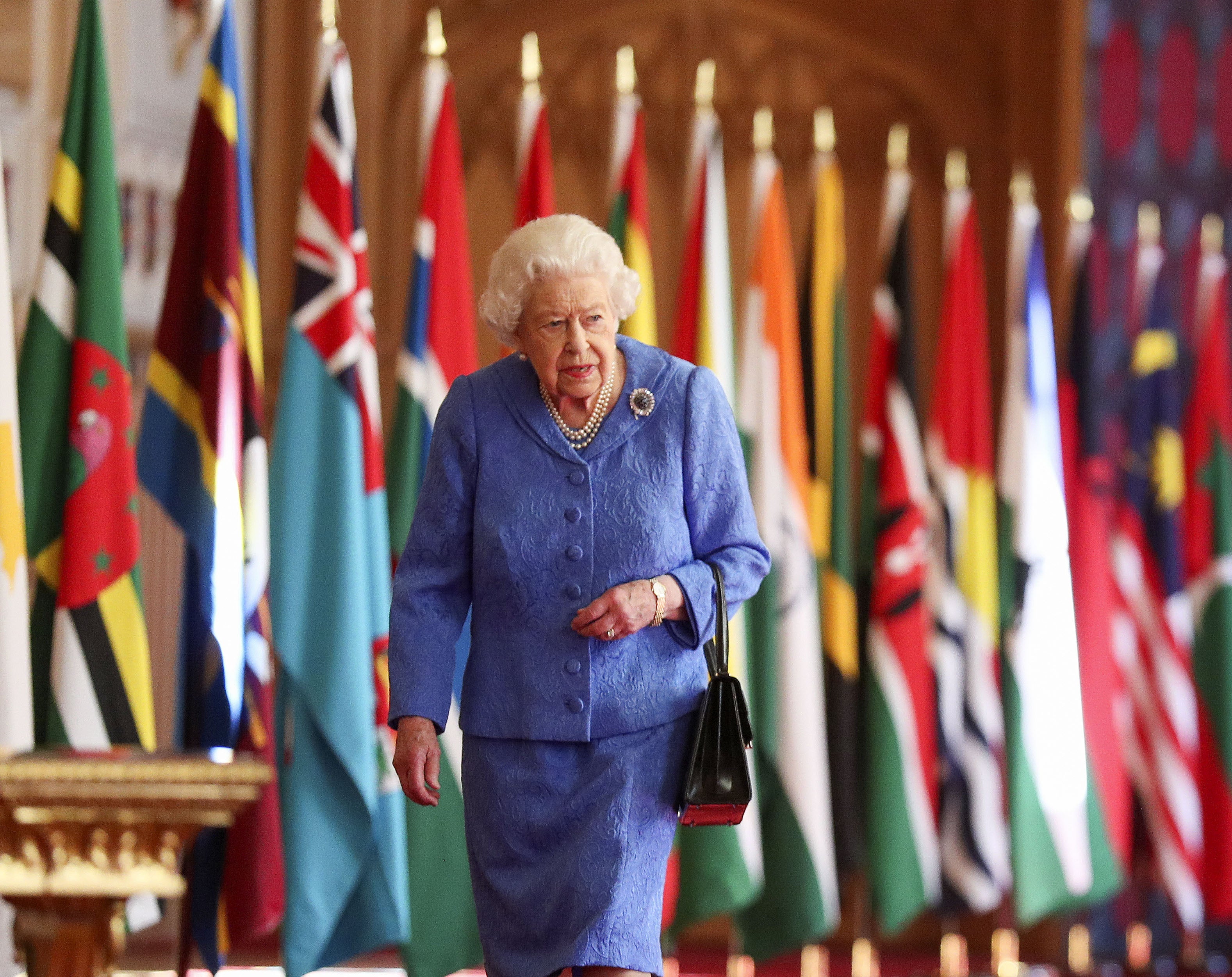 Queen Elizabeth II walks past Commonwealth flags in St George’s Hall at Windsor Castle , to mark Commonwealth Day 2021 (Steve Parsons/PA)