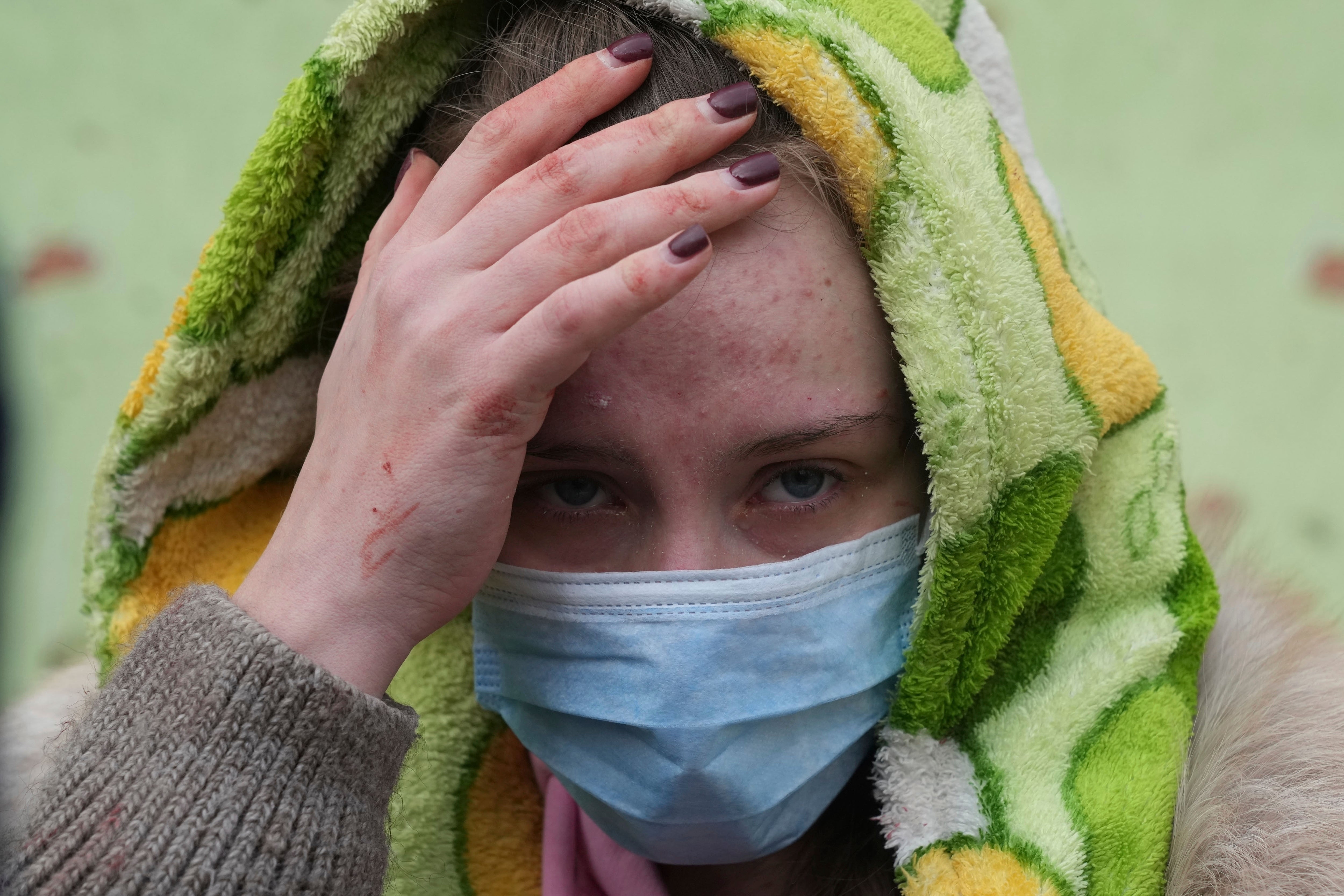 A woman walks outside a maternity hospital that was damaged by shelling in Mariupol, Ukraine, 9 March 2022