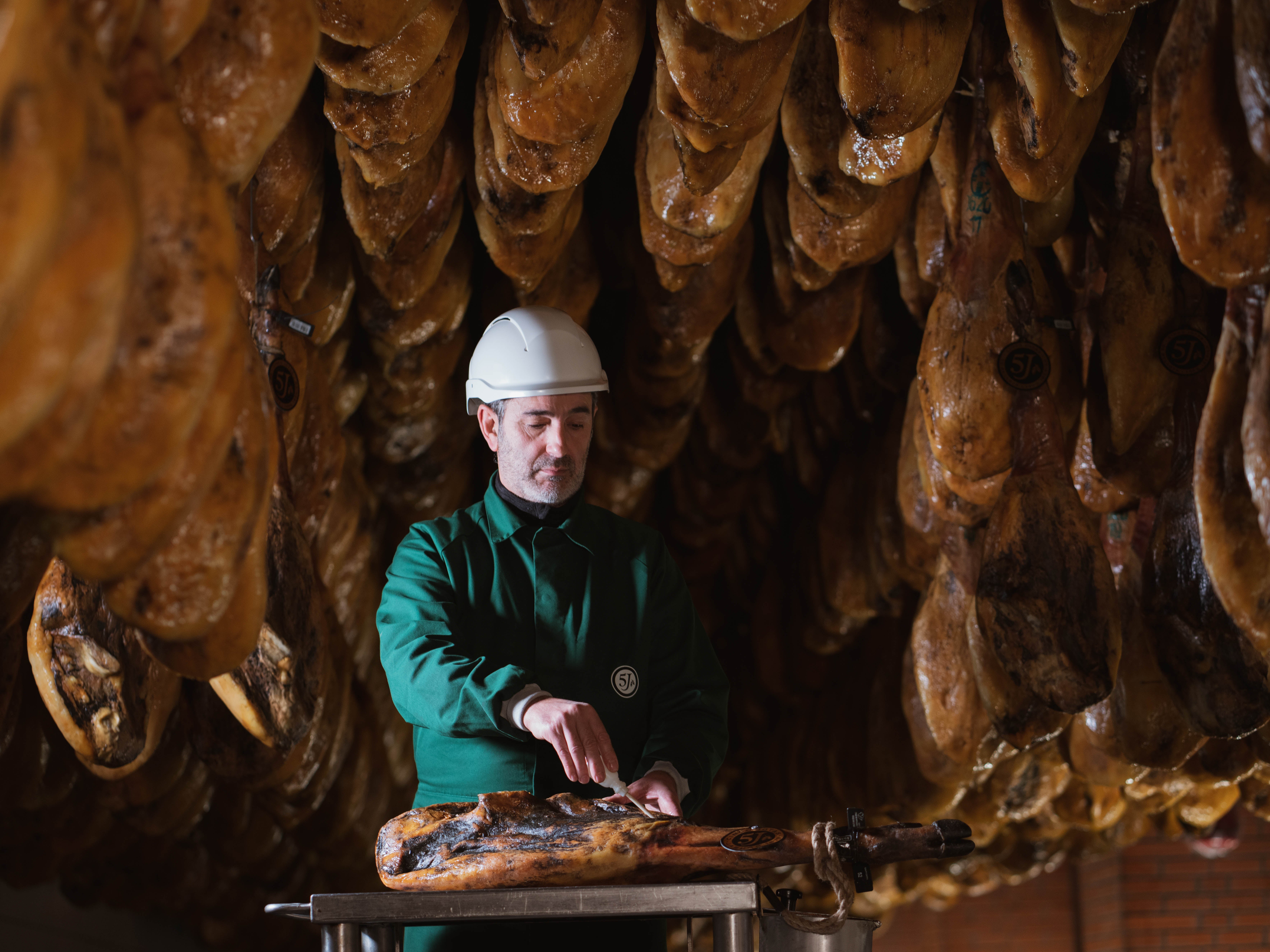 The calador uses the cala tool to test four areas of the ham before it’s ready to be sold