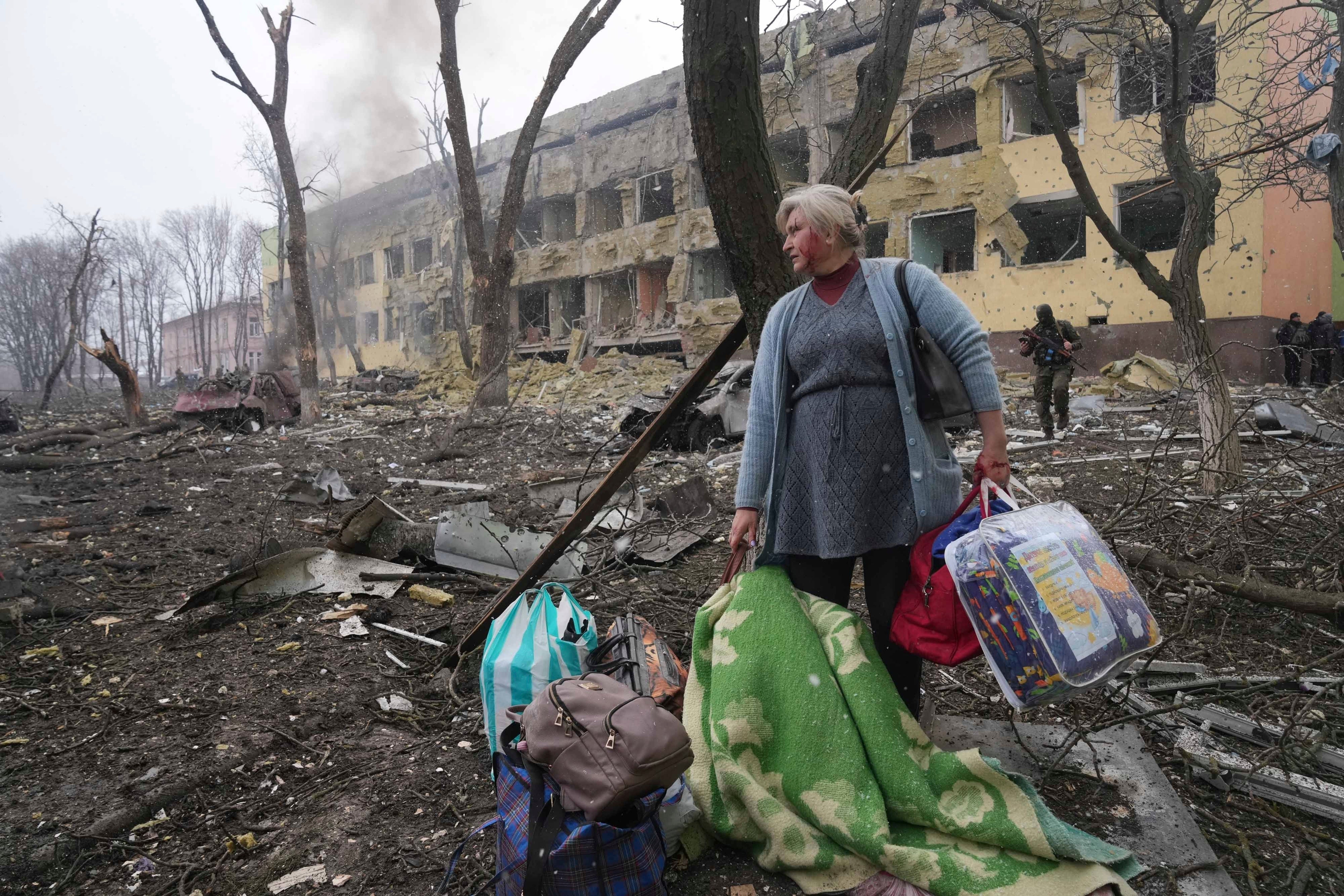 A woman stands in a ruined square after the Russian bombing.