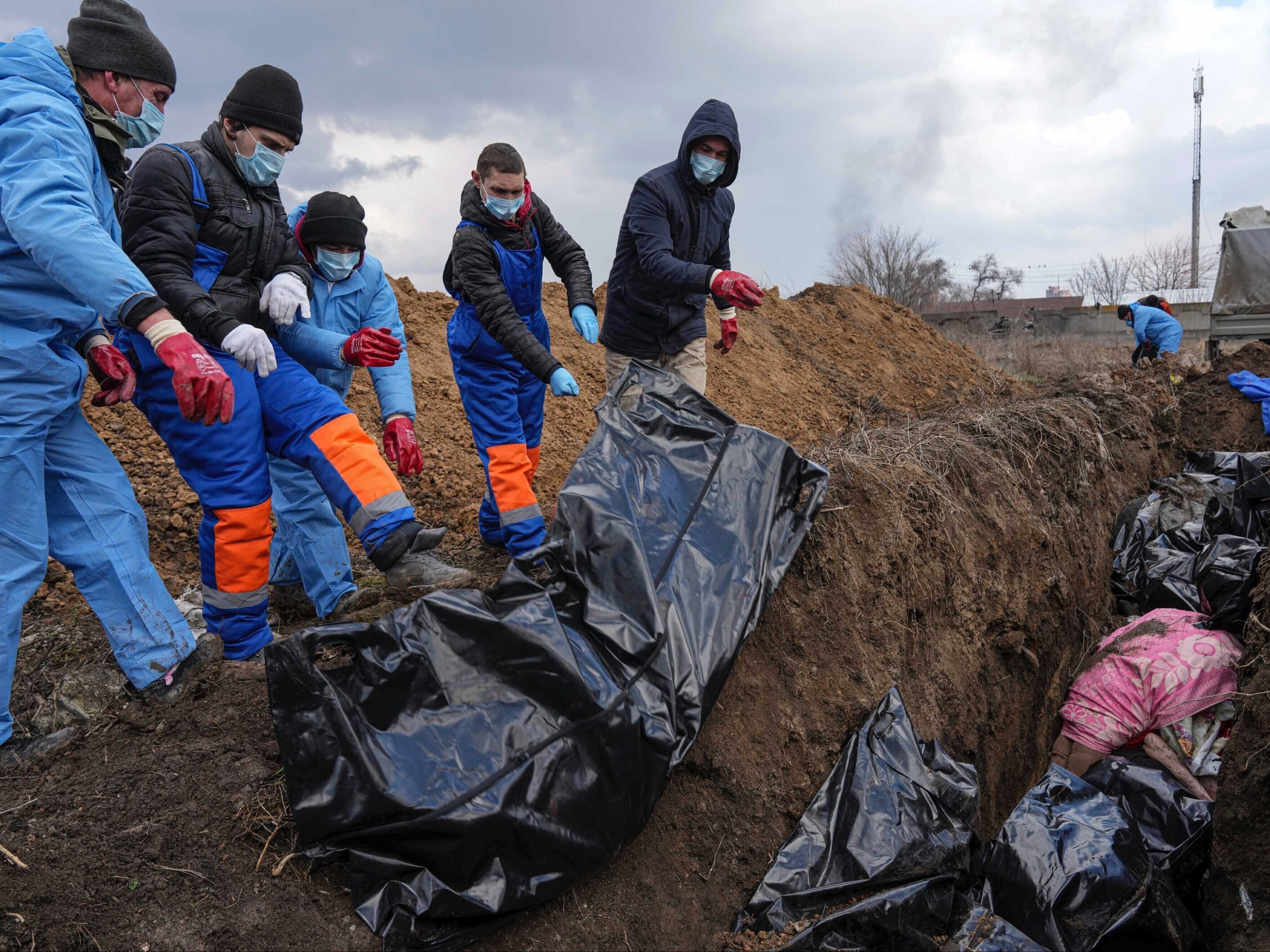 Dead bodies are placed into a mass grave on the outskirts of Mariupol