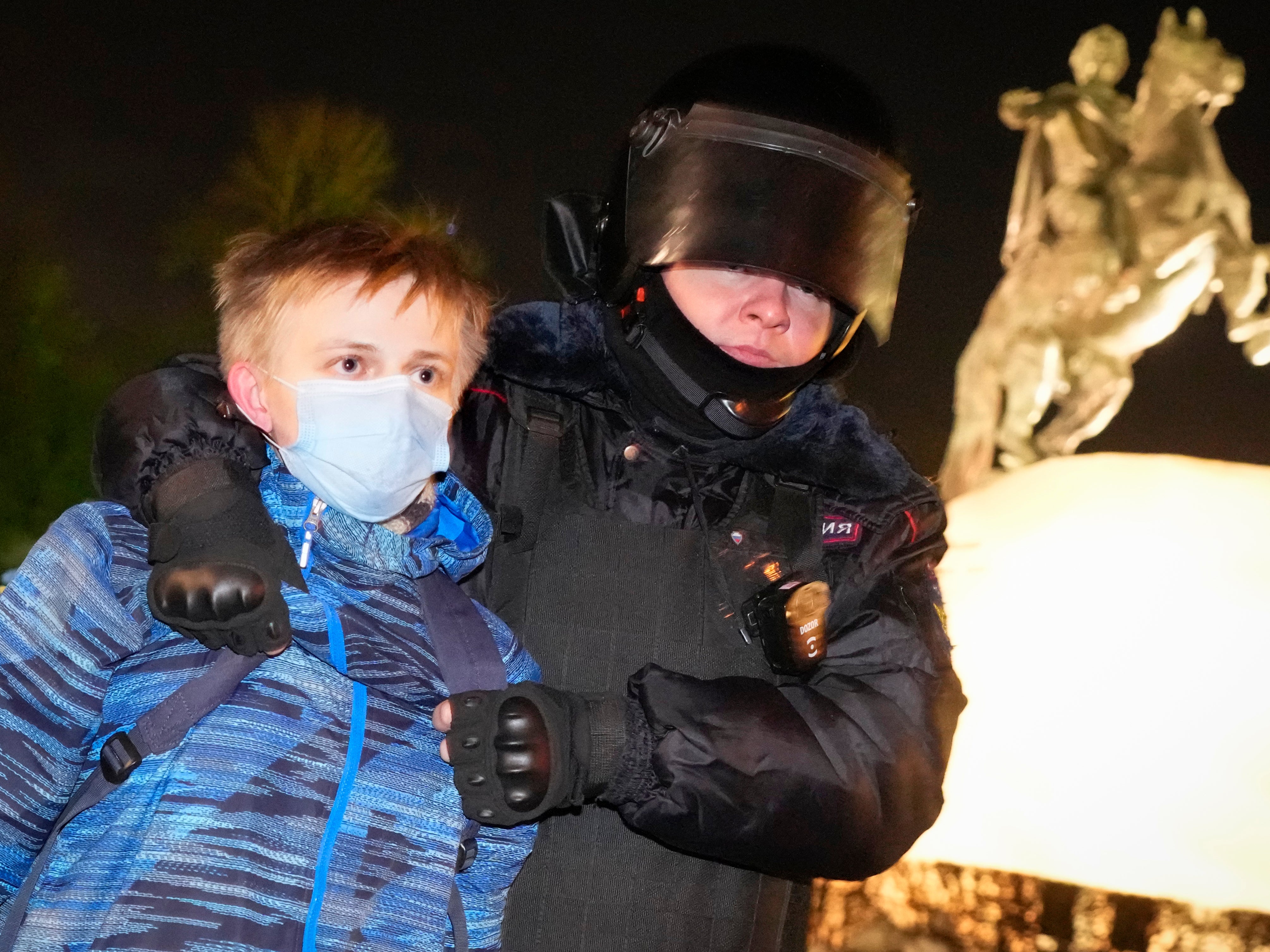 A police officer detains a young demonstrator in St Petersburg