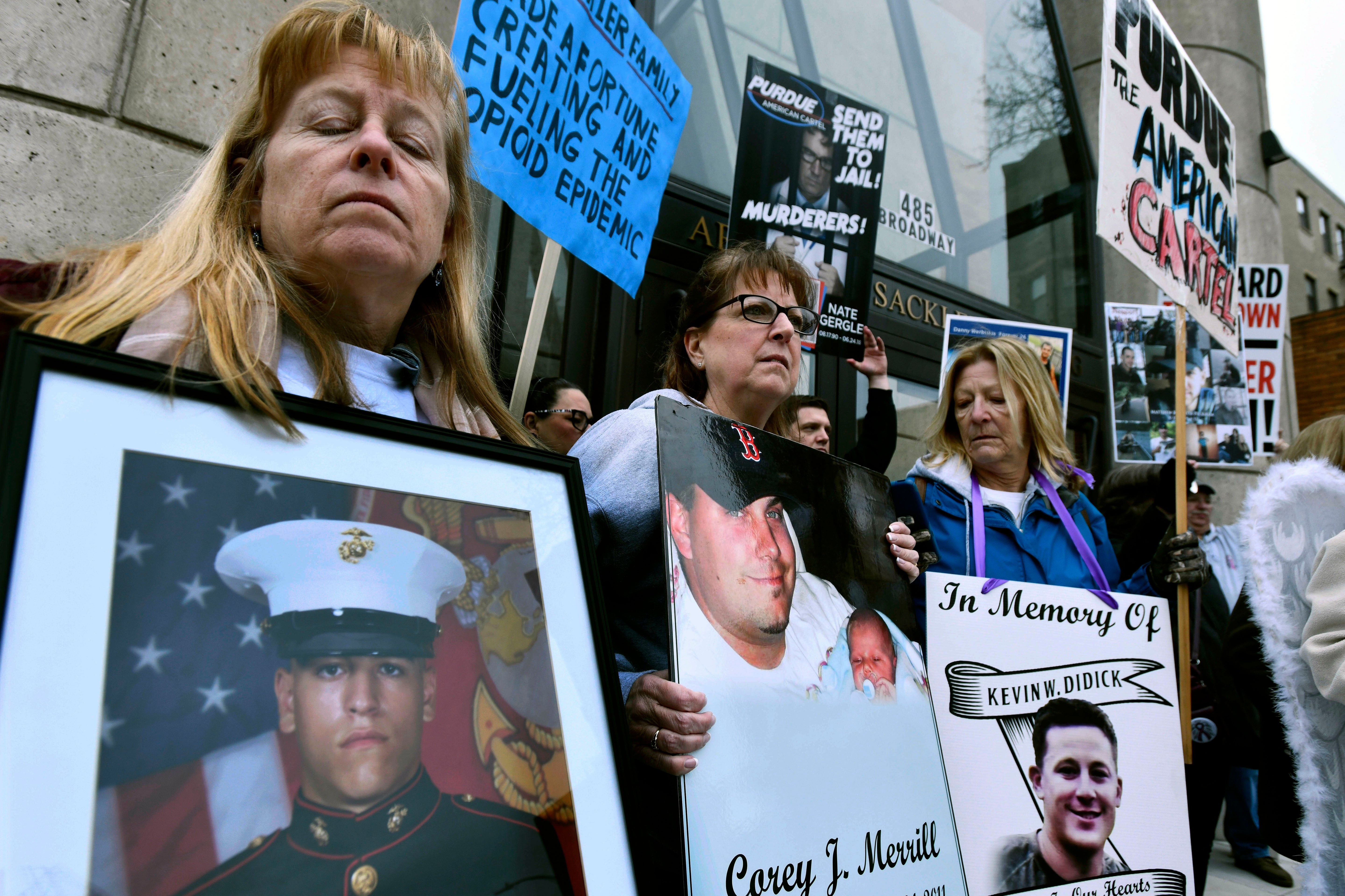 Kathleen Scarpone, left, of Kingston, NH, and Cheryl Juaire, second from left, of Marlborough, Mass, protest in front of the Arthur M Sackler Museum, at Harvard University, April 12, 2019, in Cambridge, Mass