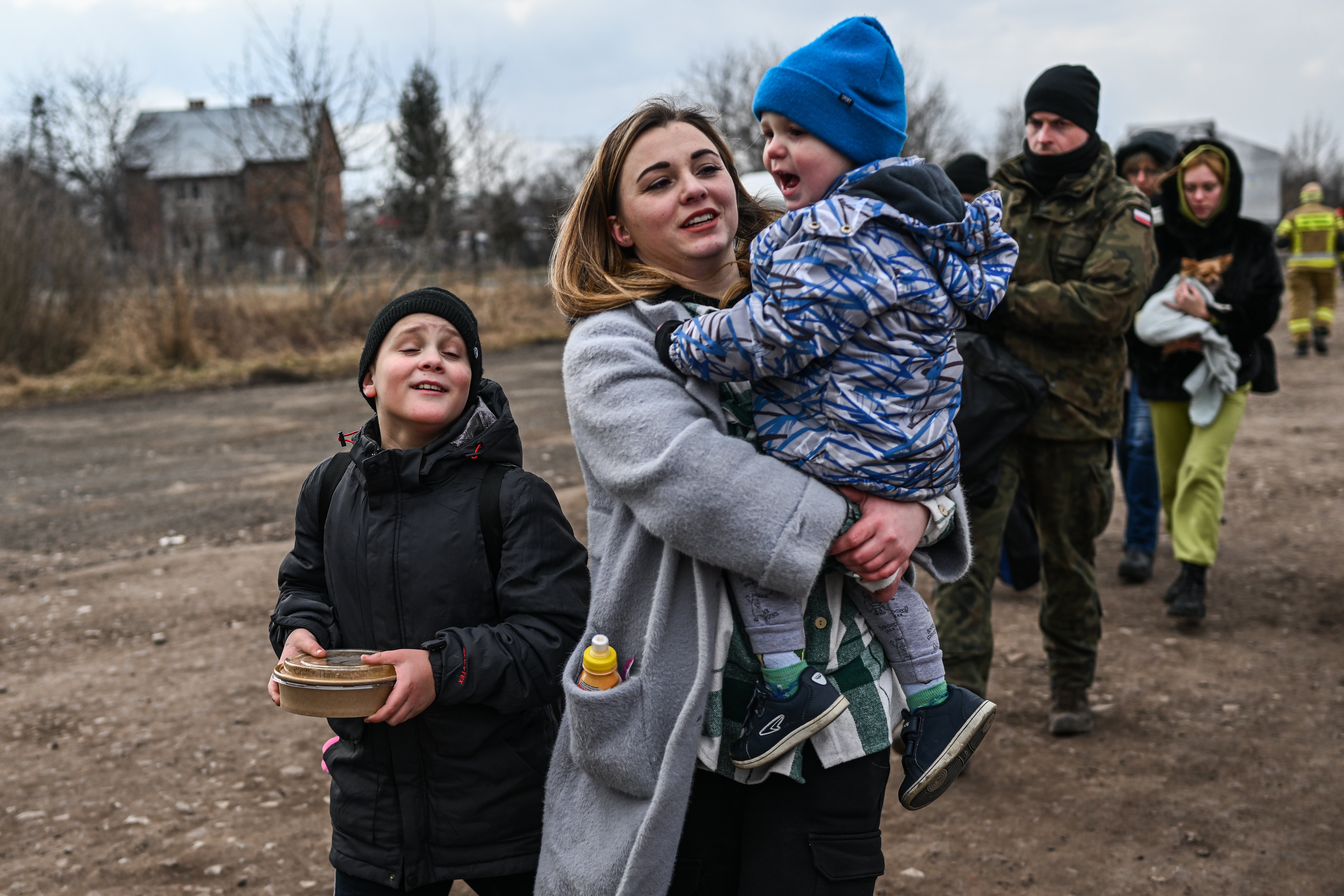 Women and children who have fled war-town Ukraine walk to board a train to transport them to Przemysl main train station after crossing the Polish Ukrainian border