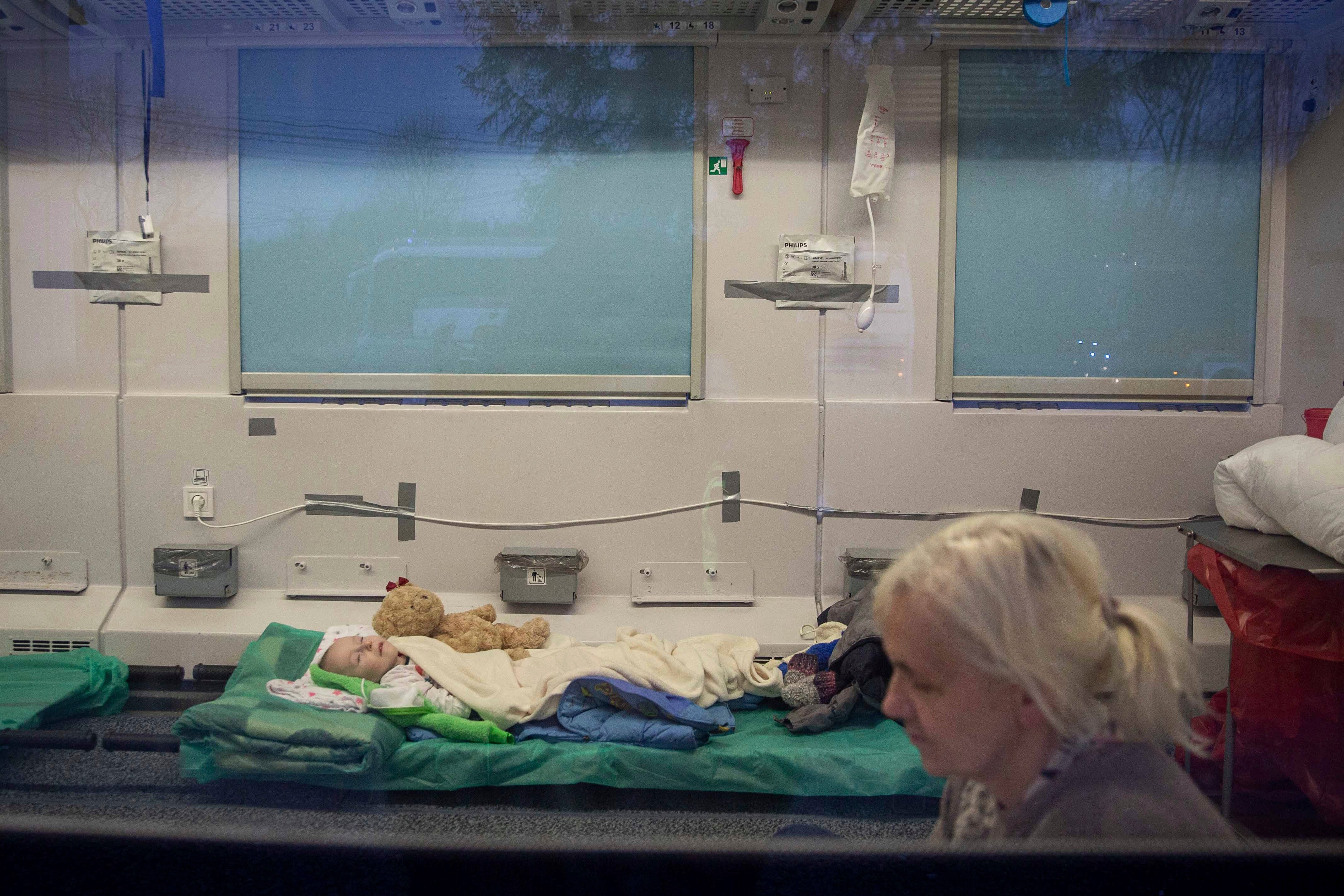 Family members accompany disabled children in a special train heading for Gdansk, near the border crossing in Medyka, Poland