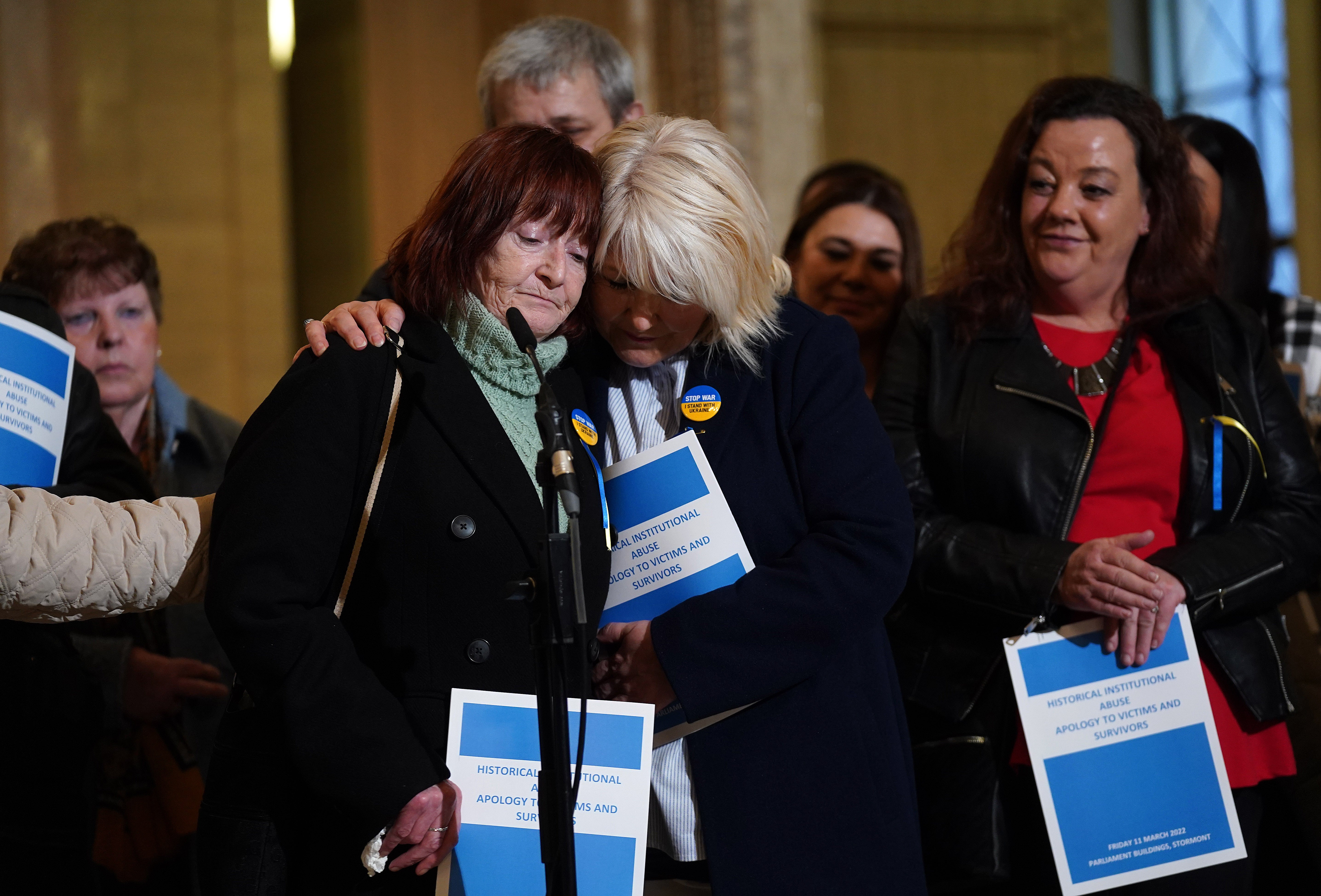 Kate Walmsley (left) and Margaret McGuckin (centre) react to the long-awaited public apology to victims of historical institutional abuse (Brian Lawless/PA)