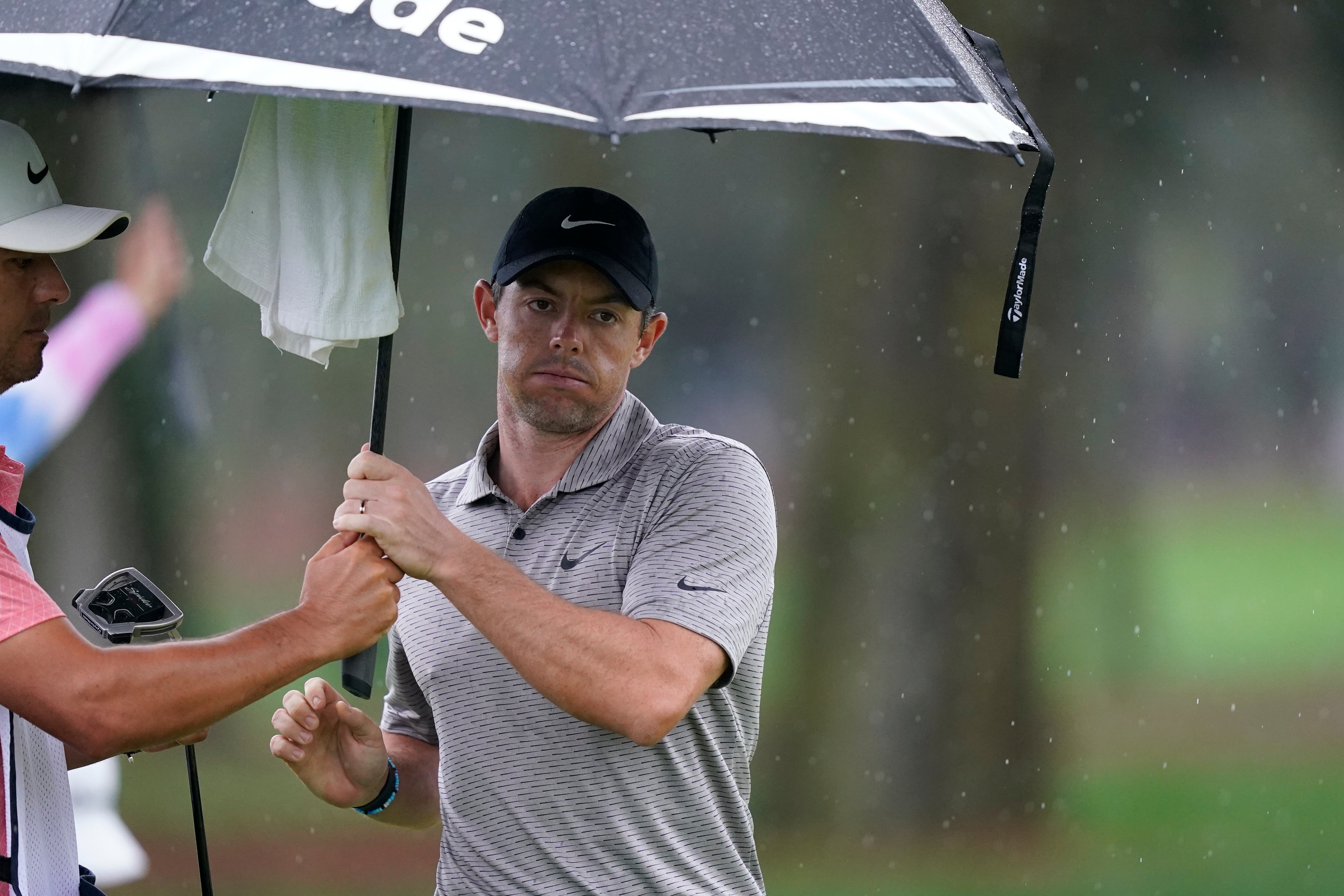 Rory McIlroy tries to stay dry on the ninth green during the first round of the Players Championship (Gerald Herbert/AP)