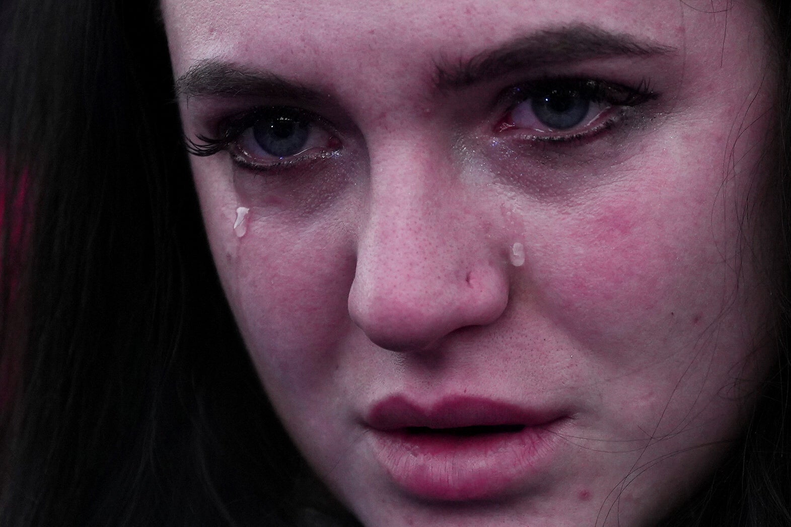 A woman cries as people wait after crossing the border from Ukraine to Poland, after fleeing the Russian invasion of Ukraine