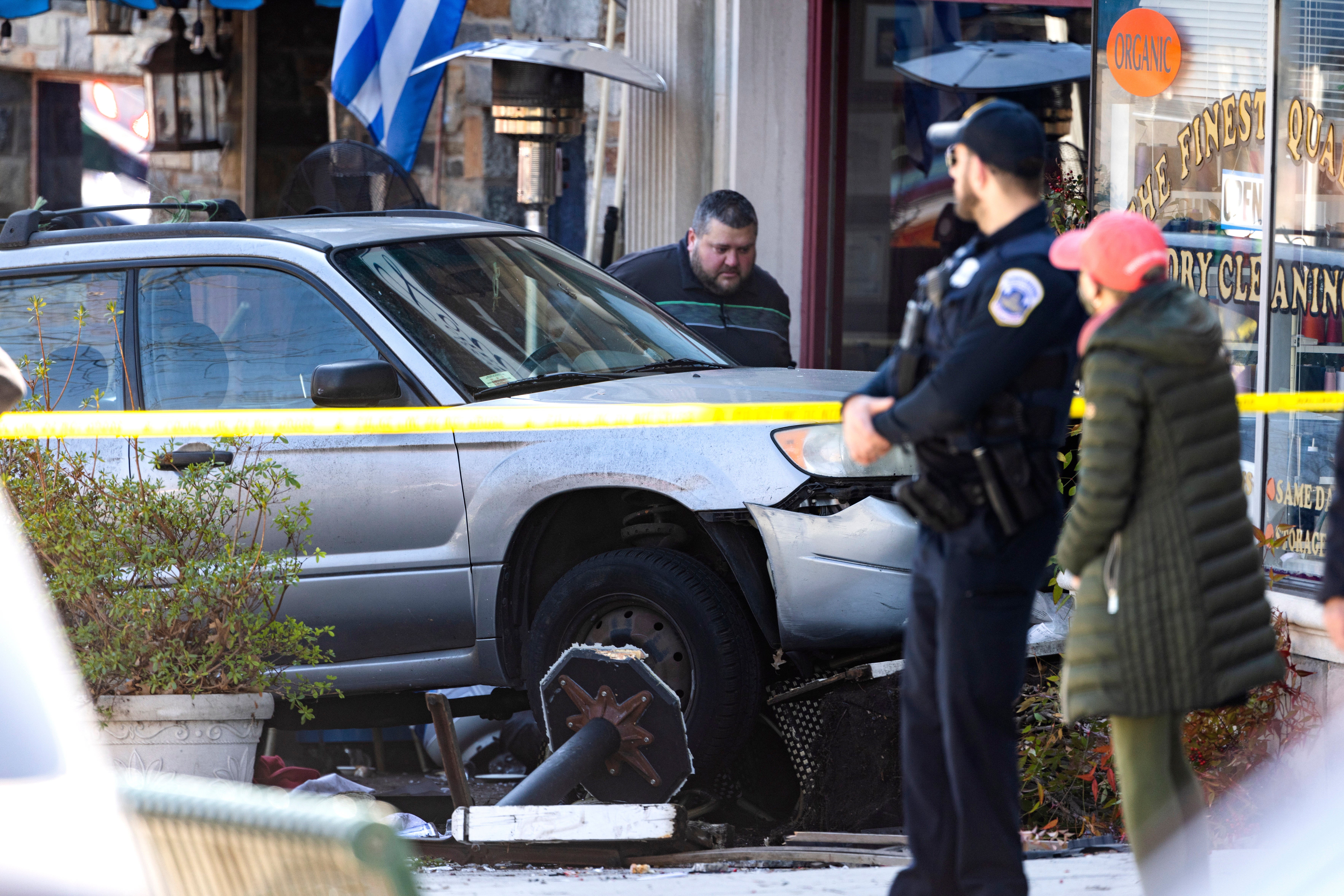 Emergency personal surround a vehicle that crashed into diners who were eating at the Parthenon Restaurant remains on the sidewalk in the Chevy Chase neighborhood of Washington, DC, USA, 11 March 2022