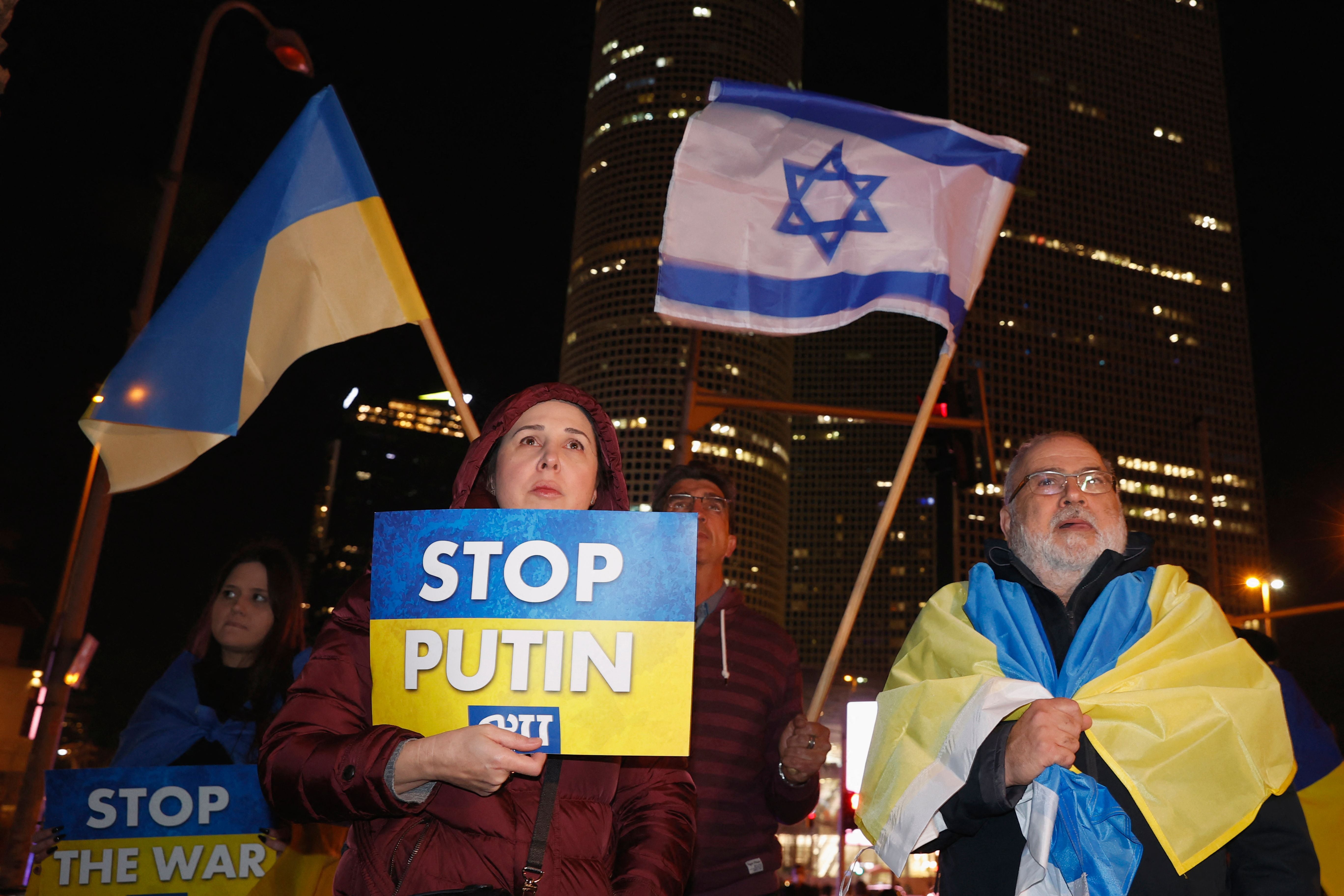 People wave Ukrainian and Israeli flags during a protest against Russia's military invasion of Ukraine, in Israel's Mediterranean coastal city of Tel Aviv on March 12, 2022