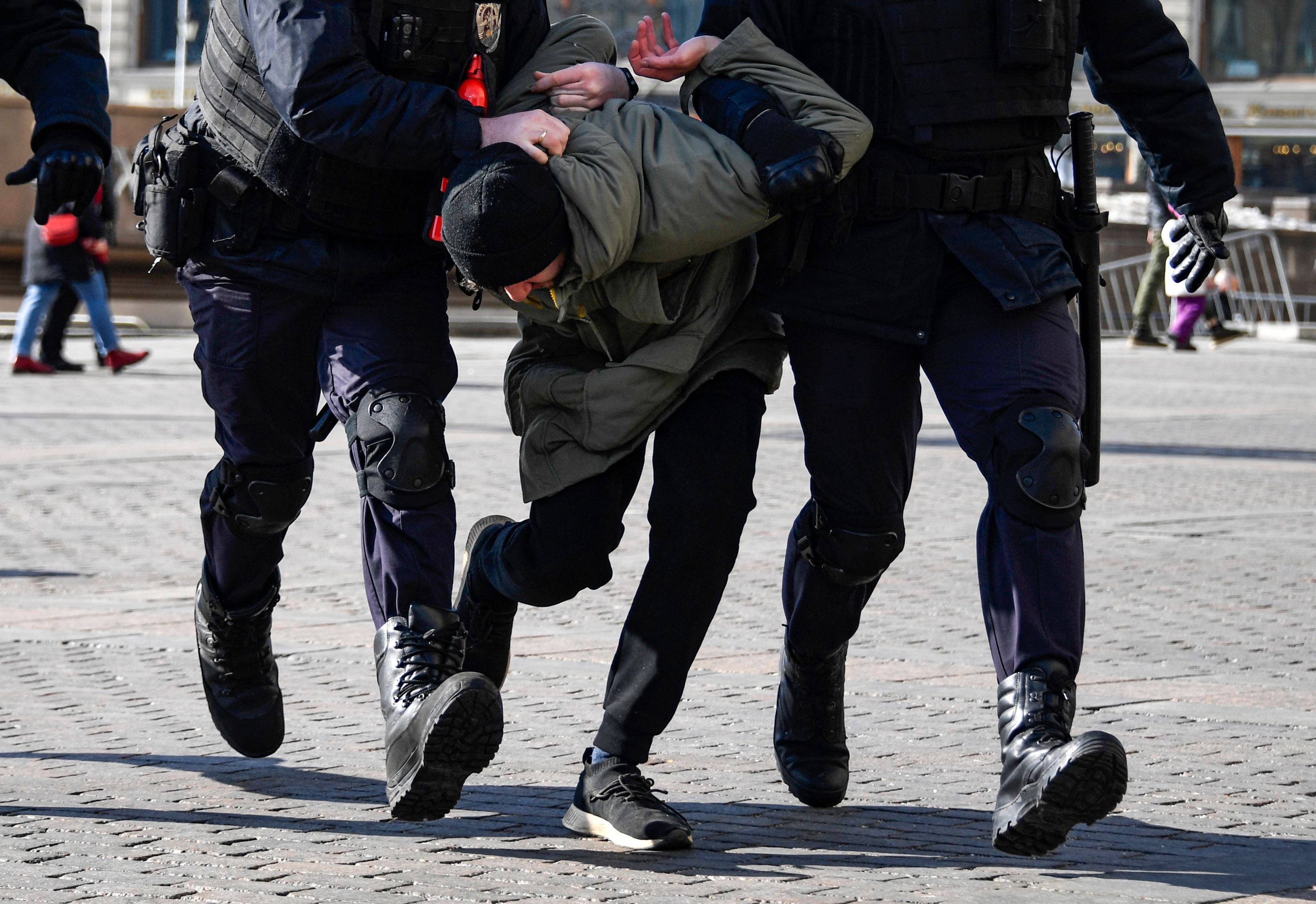 Police officers detain a man during a protest against Russian military action in Ukraine, in central Moscow