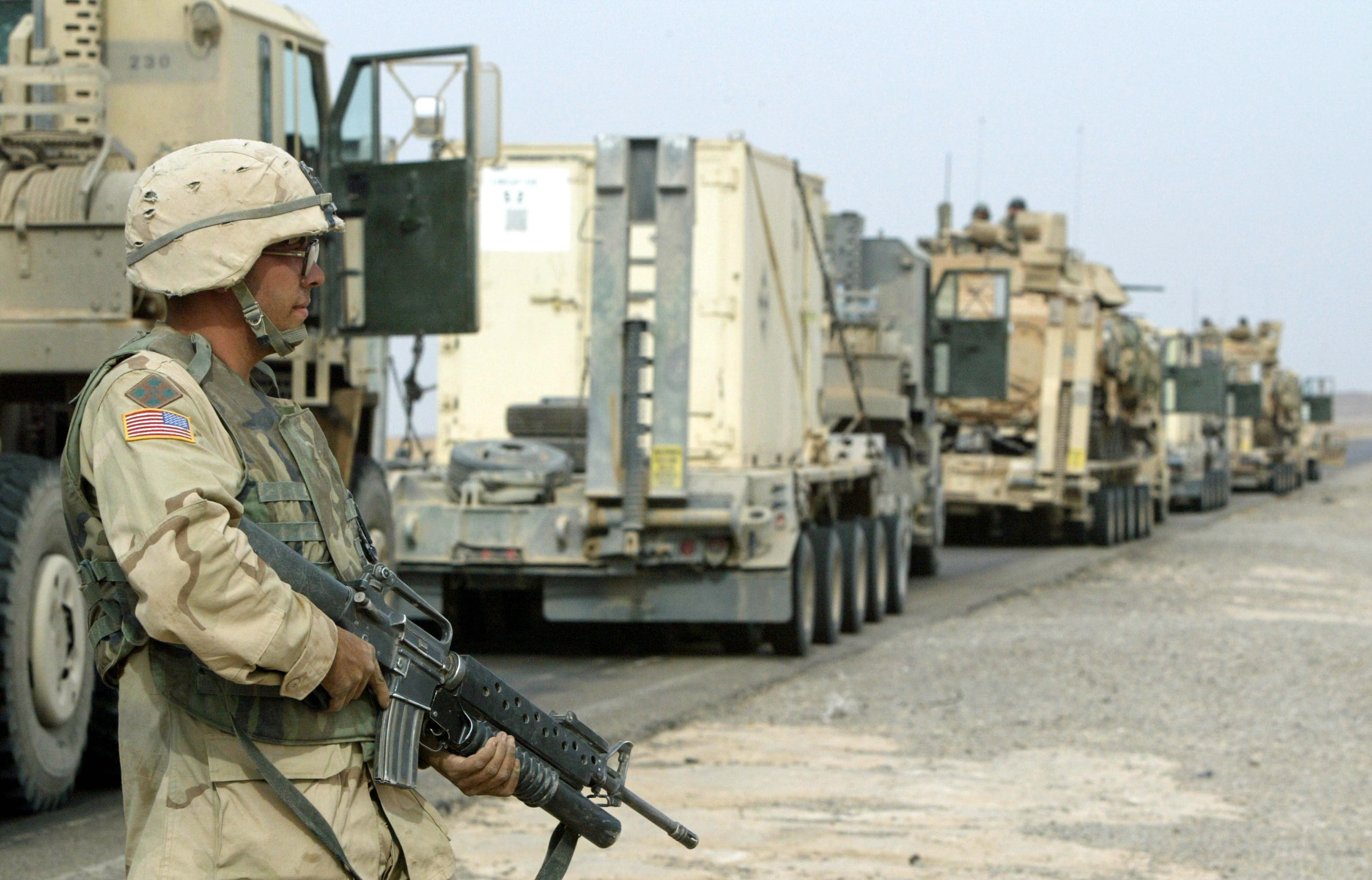 A US soldier stands near military trucks in Kirkuk, Iraq, 08 November 2003