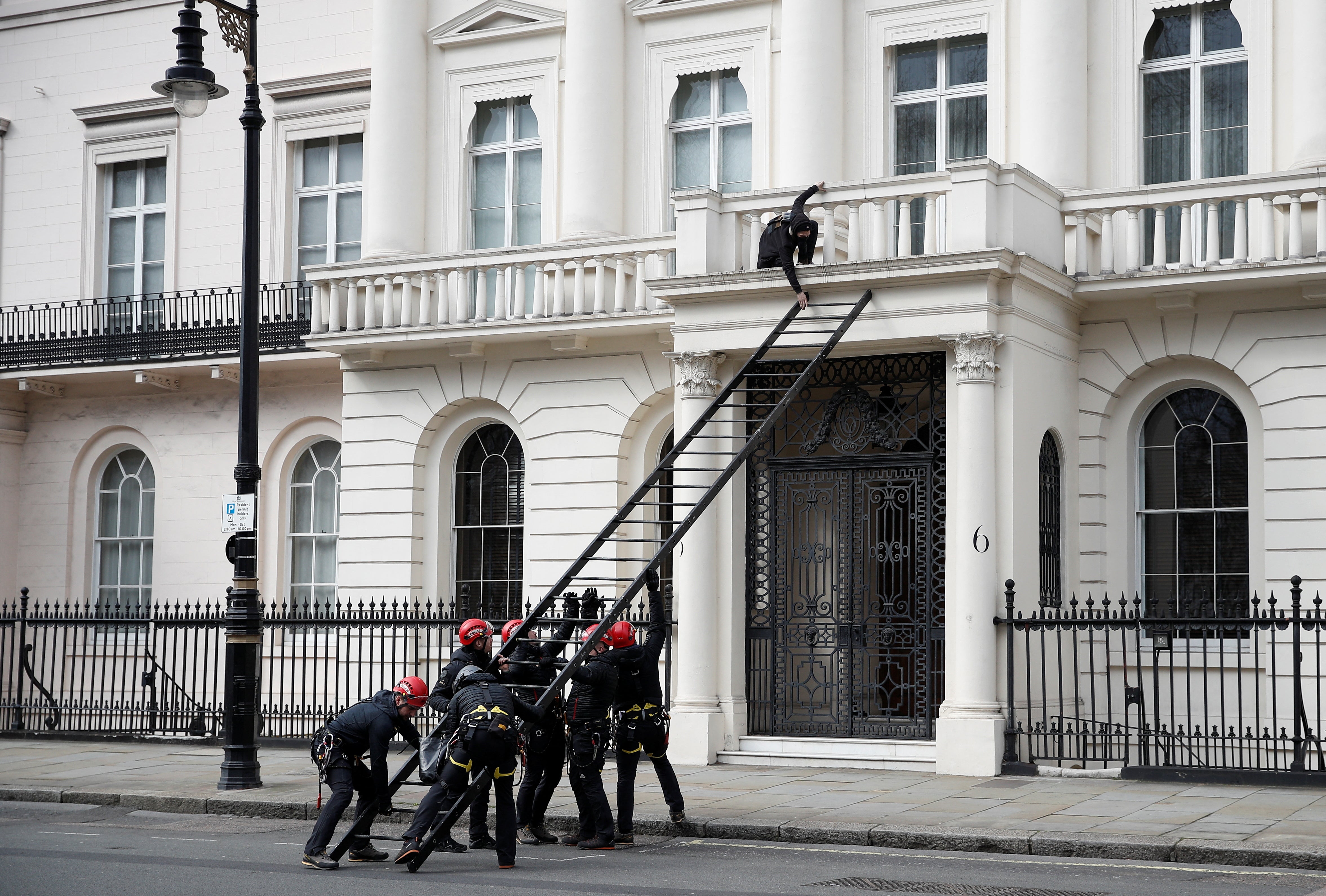 A protester tries to push away a ladder being used by police officers