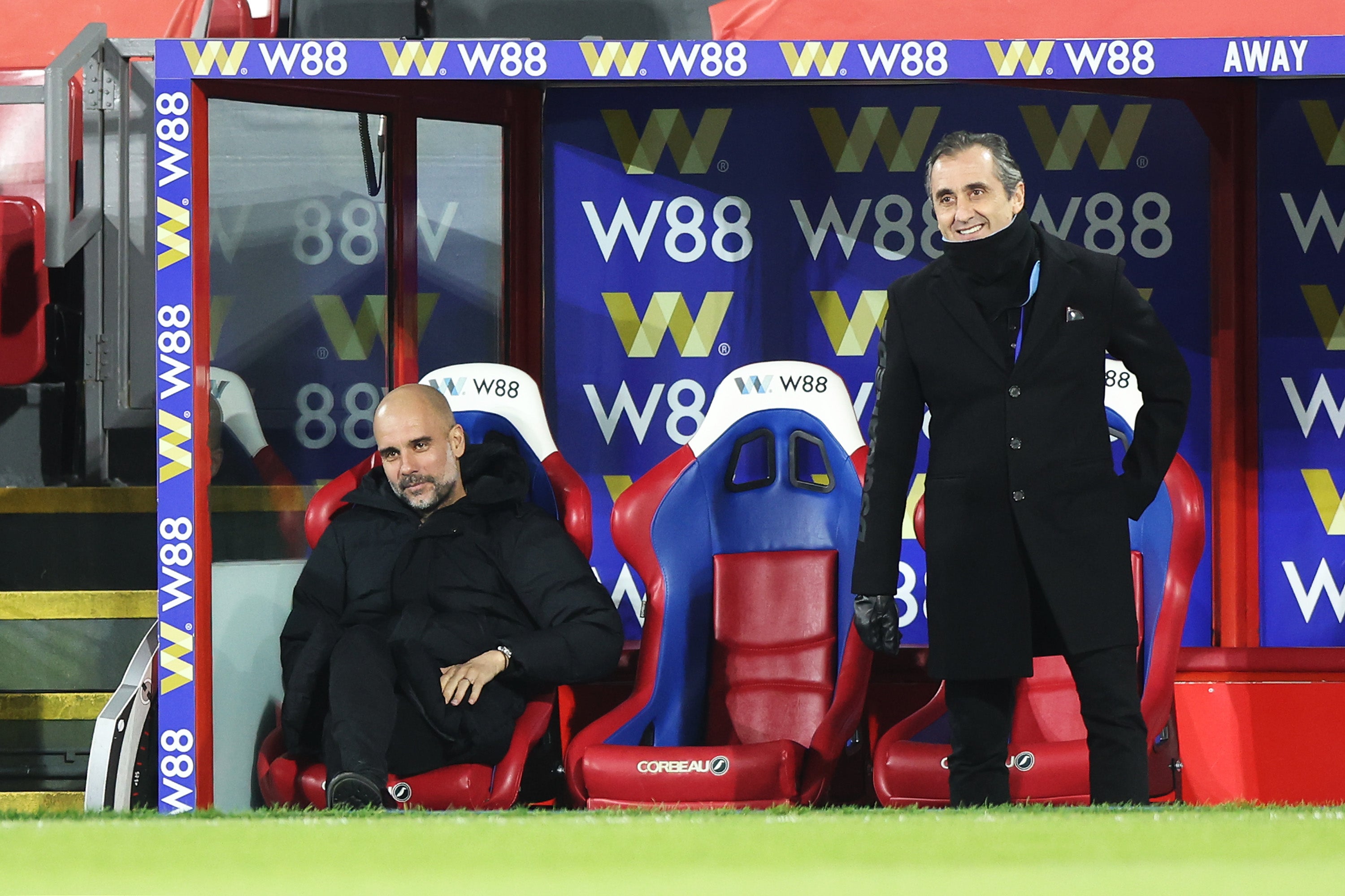 Pep Guardiola takes a seat in the dugout