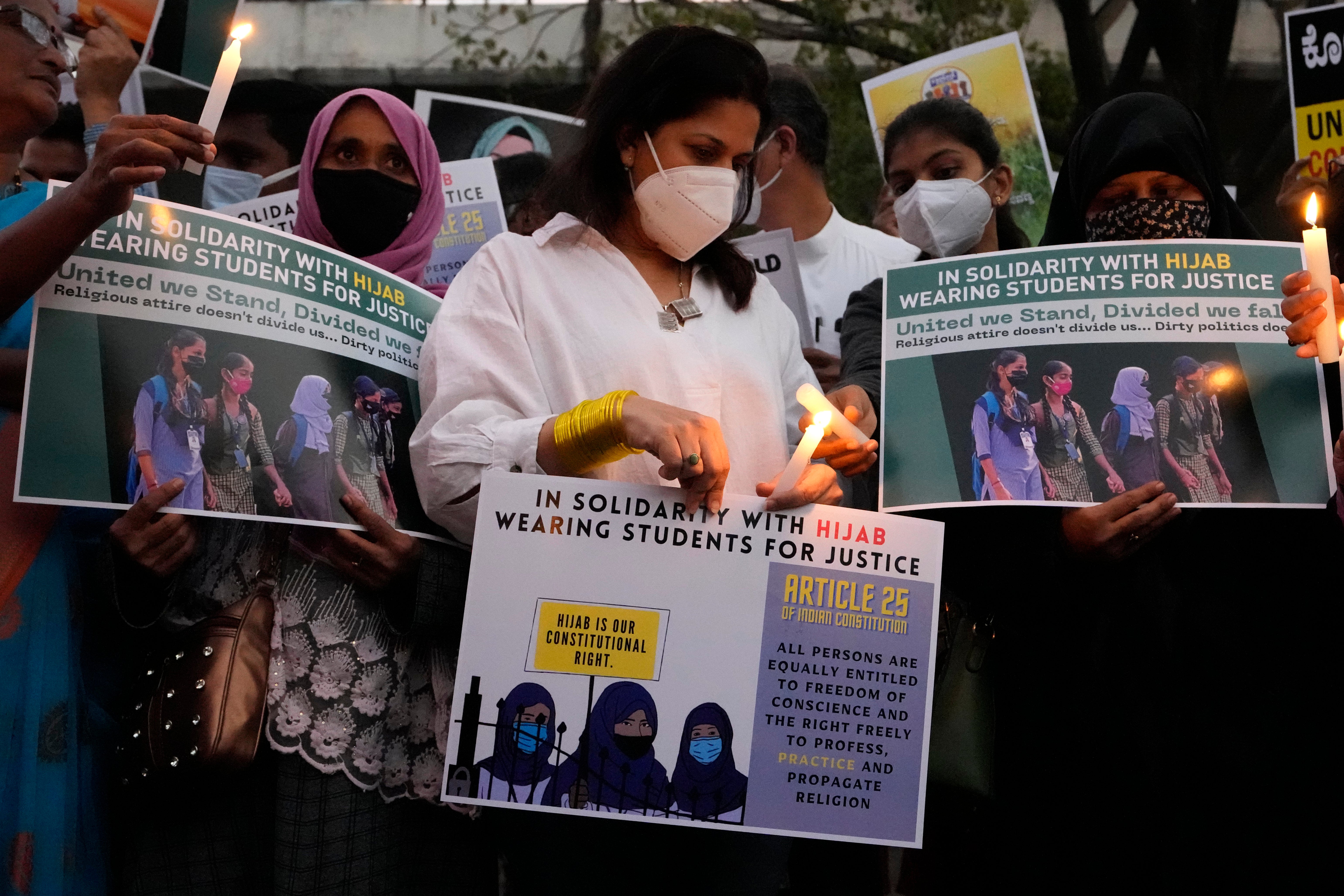 File photo: People hold placards and candles in Bengaluru, India, during a protest against banning Muslim girls from wearing the hijab in educational institutions in Karnataka on 19 February