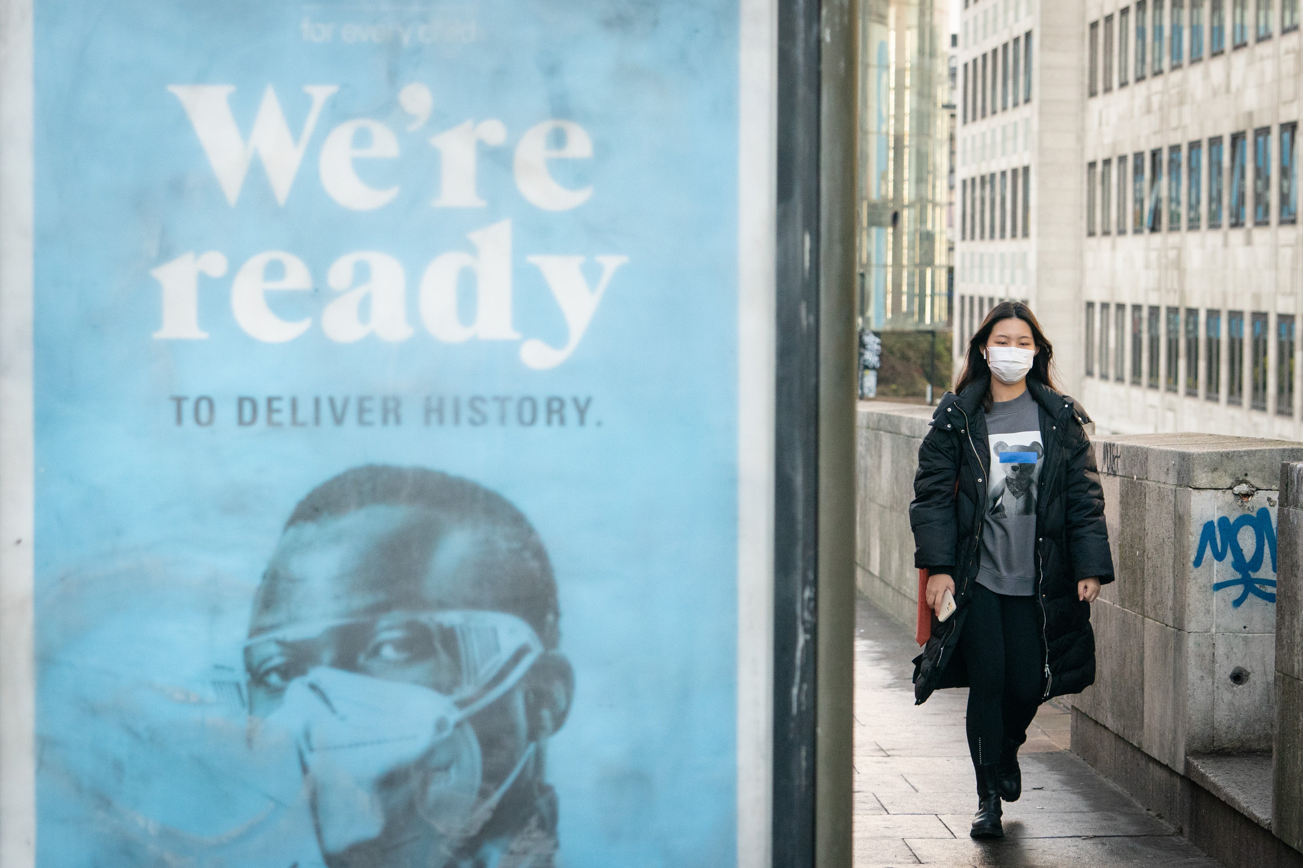 A woman wearing a face mask crosses Waterloo Bridge, London, after Prime Minister Boris Johnson announced that Plan B measures across England will be scrapped (Dominic Lipinski/PA)