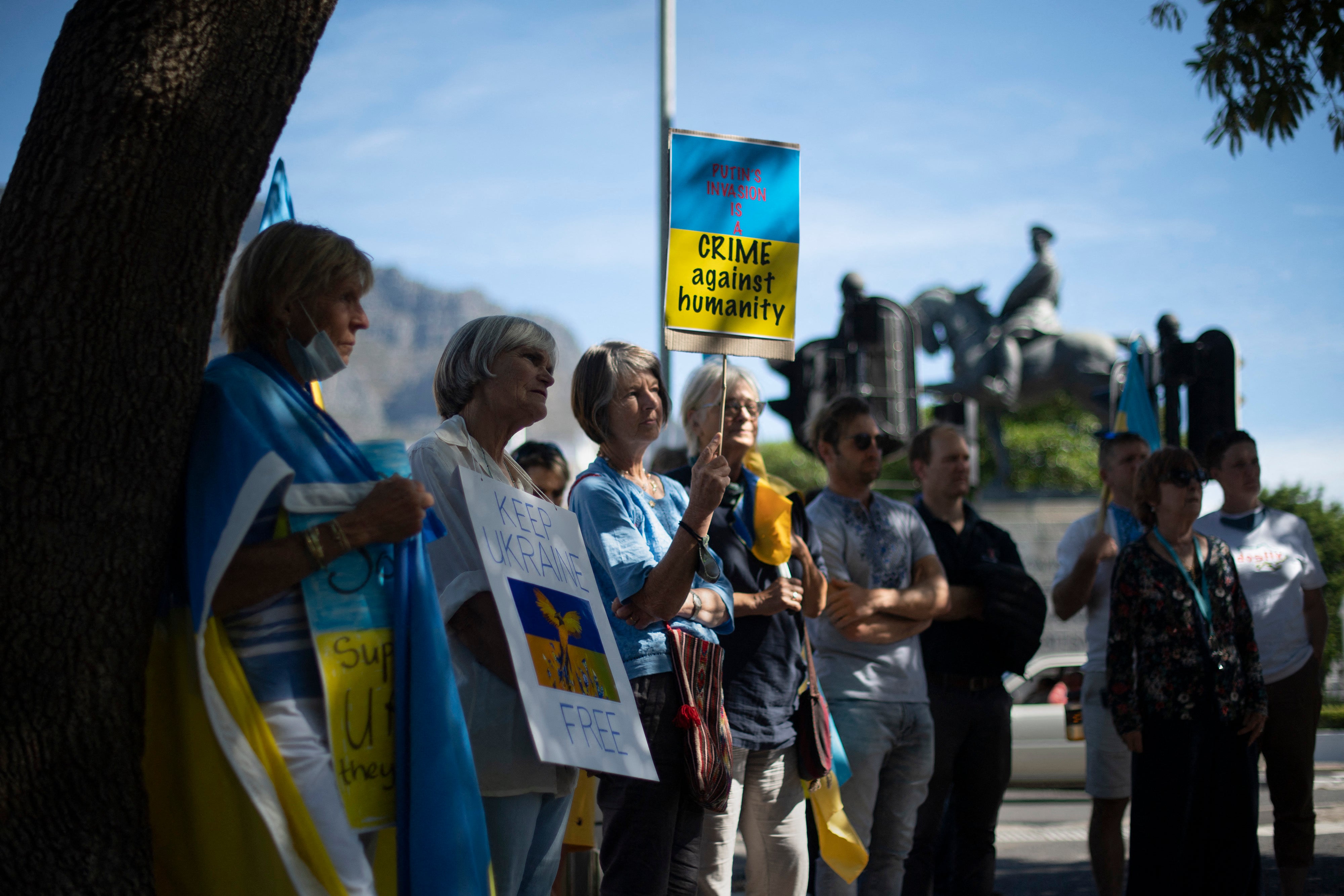 Protesters stand outside the South African parliament as a show of support for the Ukrainian people