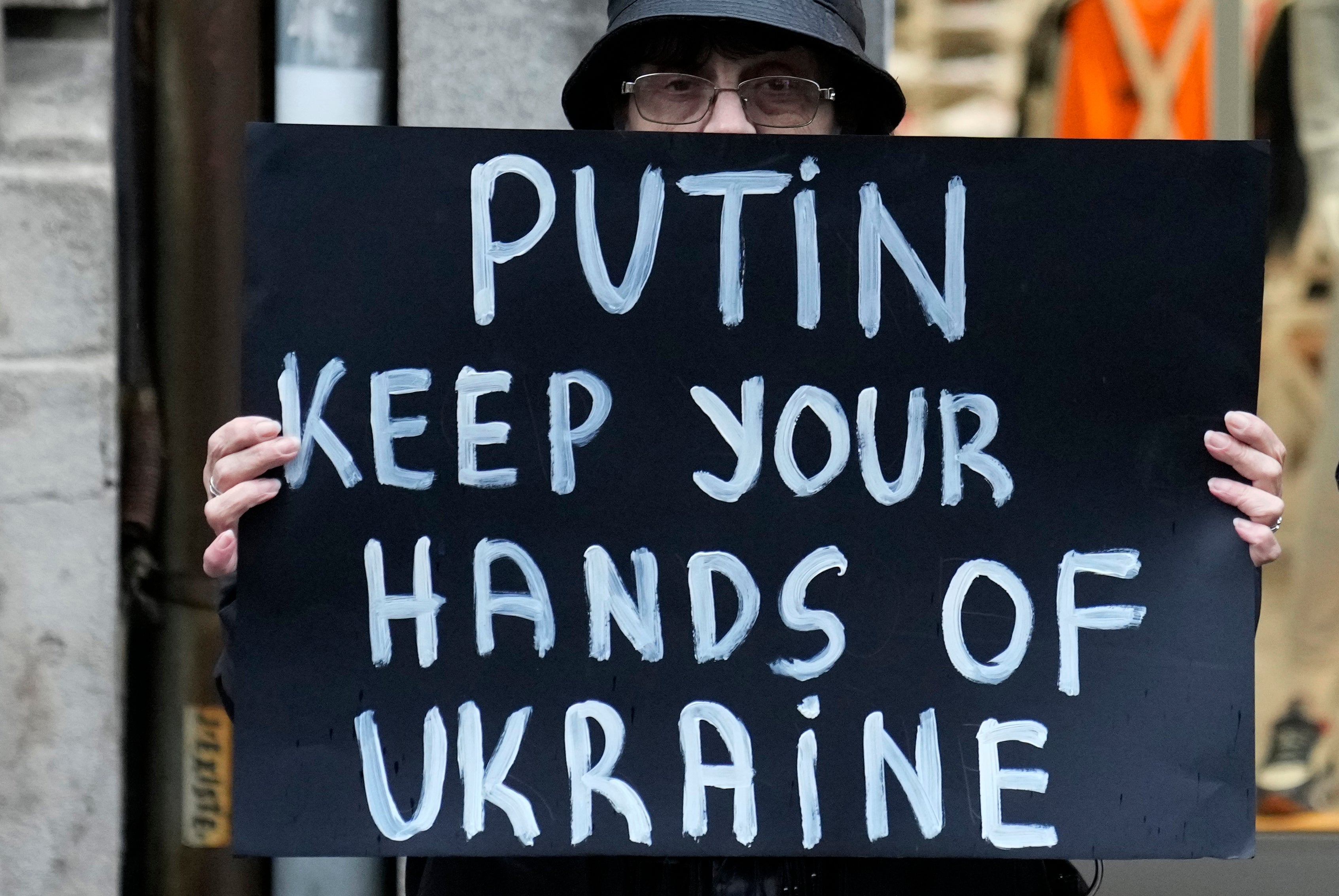 A member of the anti-war organization "Women in Black" holds a banner during a protest against the Russian invasion, in solidarity with the Ukrainian people in Belgrade, Serbia