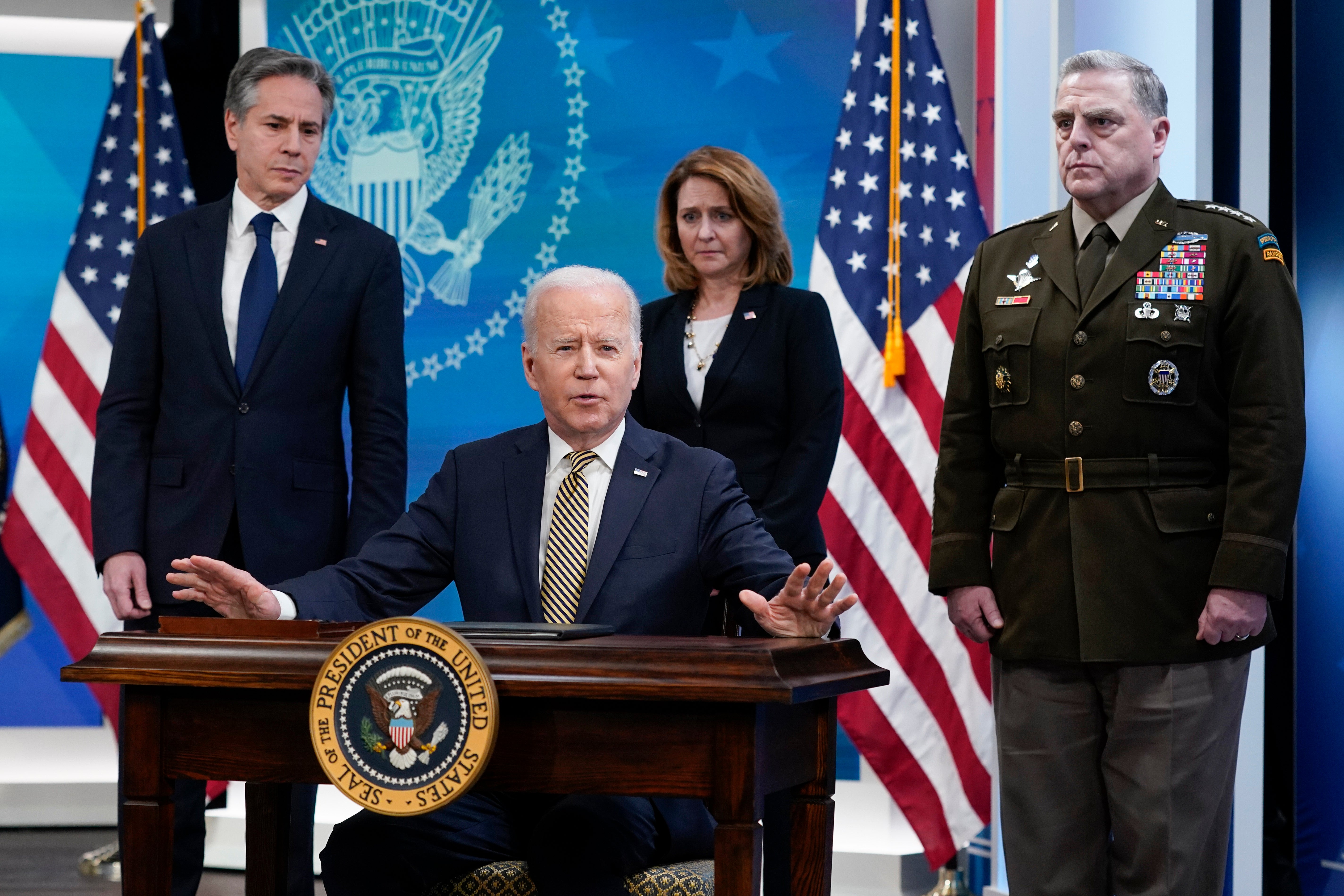 President Joe Biden speaks after signing a delegation of authority in the South Court Auditorium on the White House campus in Washington, Wednesday, March 16, 2022. From left, Secretary of State Antony Blinken, Biden, Deputy Secretary of Defense Kathleen Hicks and Chairman of the Joint Chiefs of Staff General Mark Milley. (AP Photo/Patrick Semansky)