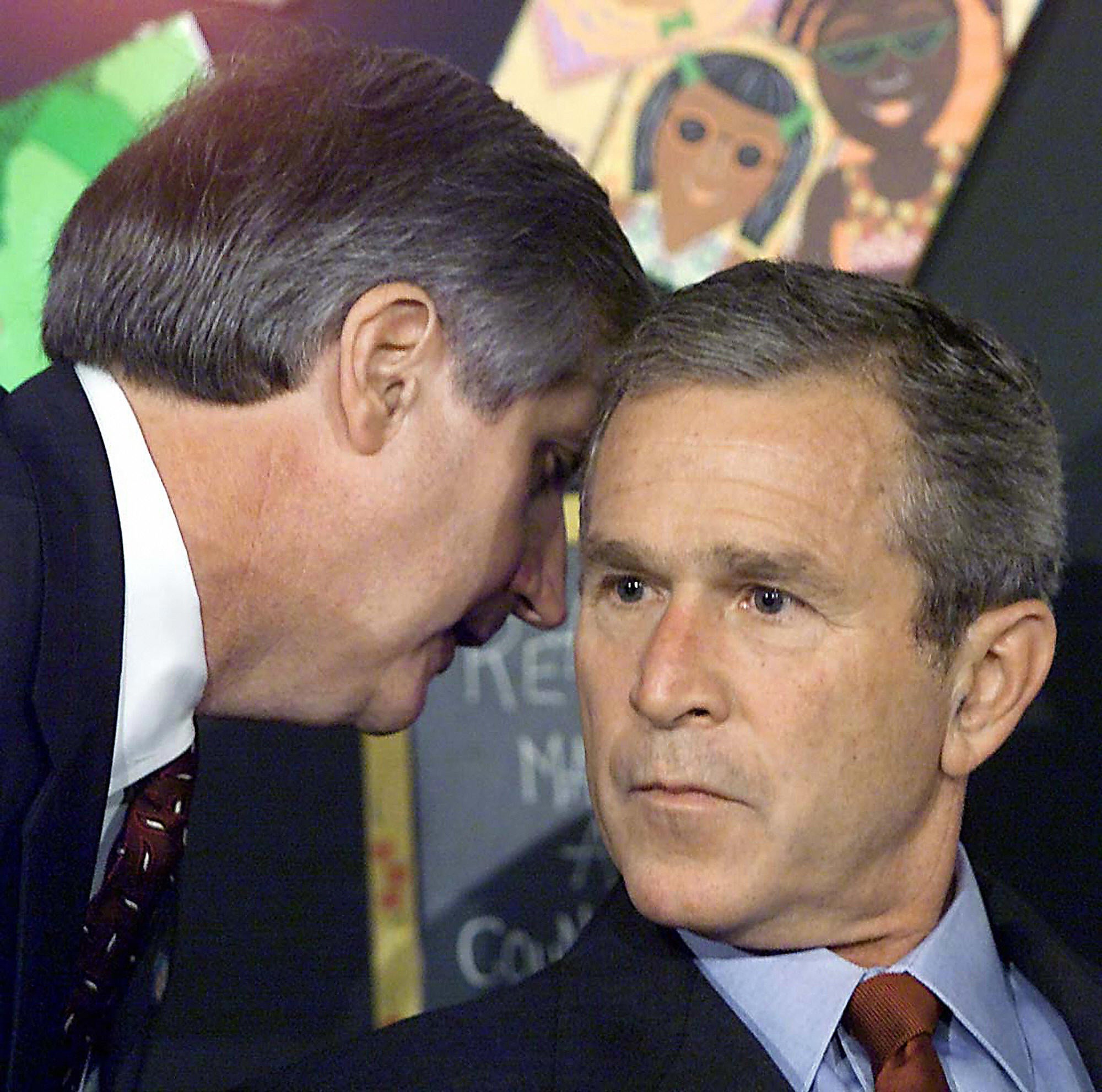 George W Bush is told about the World Trade Centre attack during an early morning school reading event