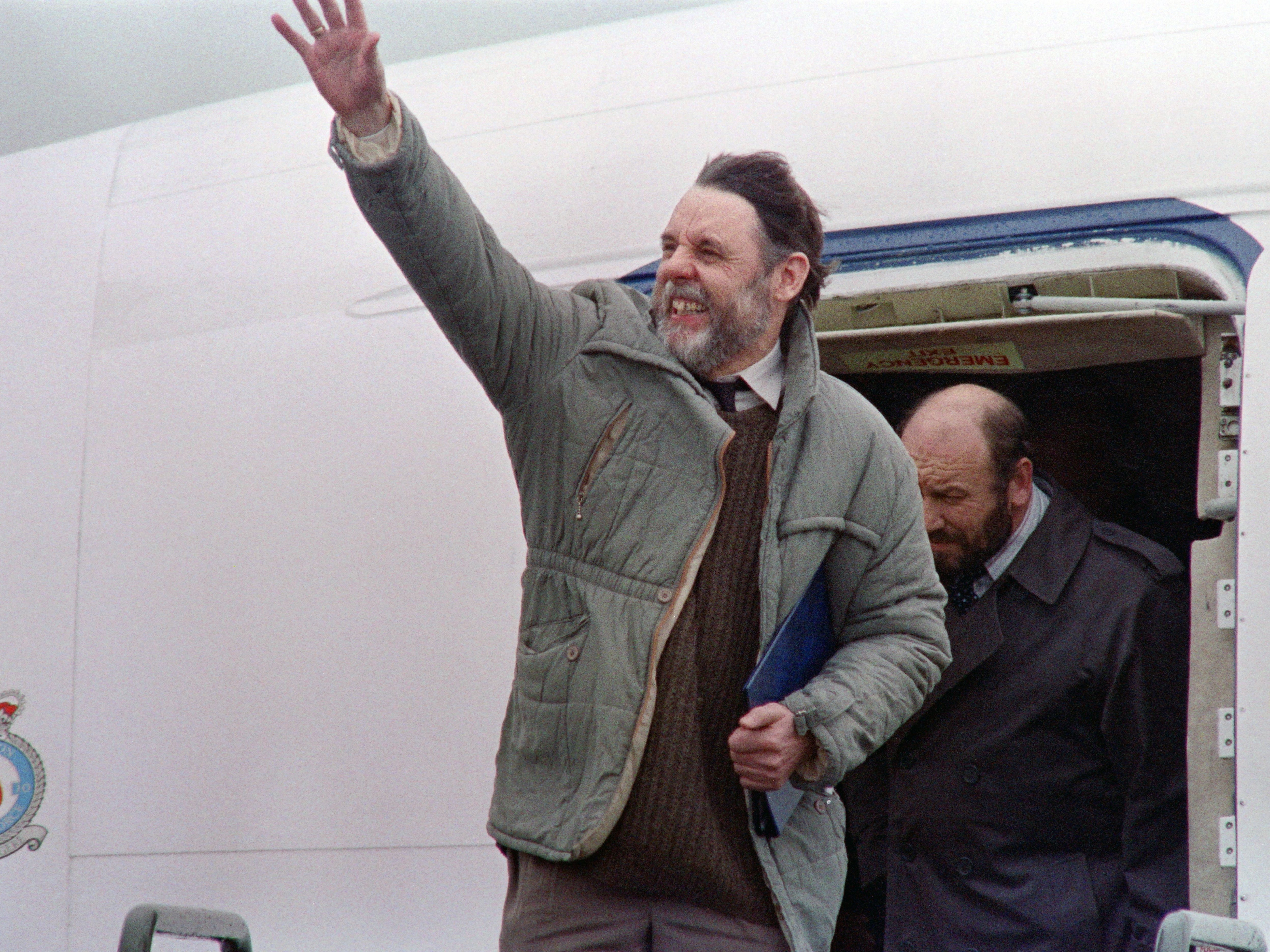 Terry Waite waves as he arrives in Lyneham, Wiltshire, on 19 November 1991, following his release in Lebanon