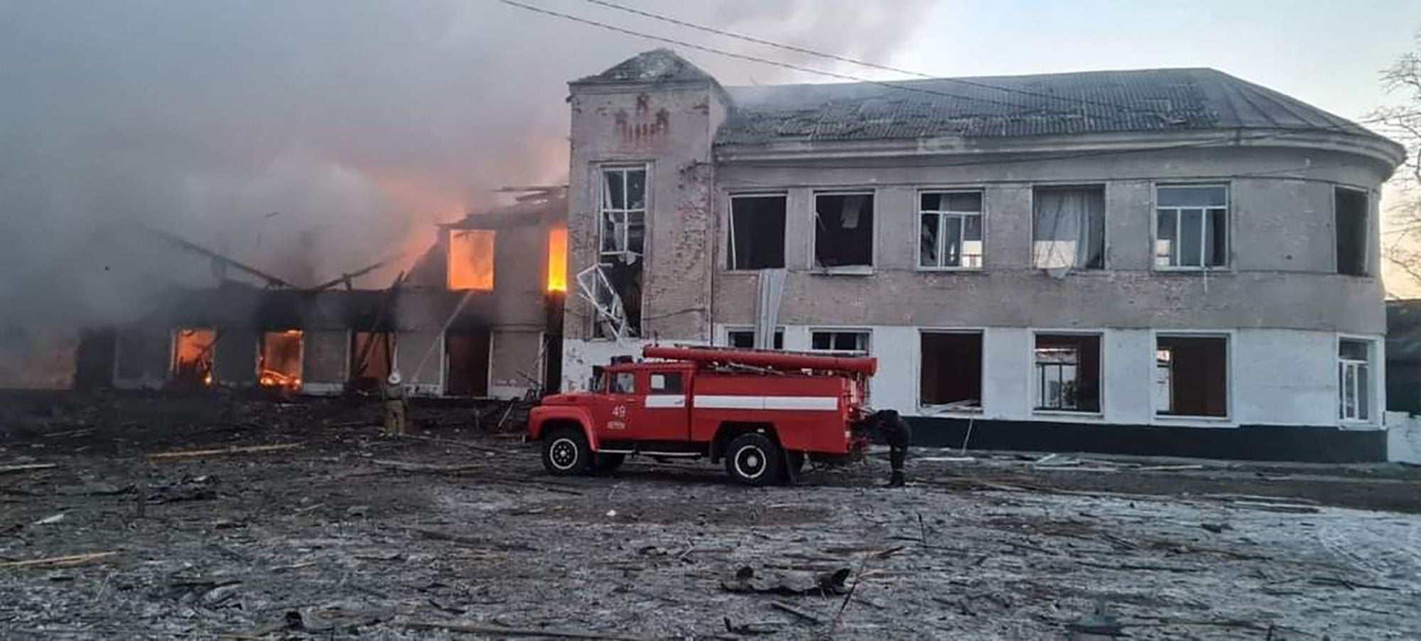 Firemen work to extinguish a fire at an educational institution hit by shelling in the town of Merefa