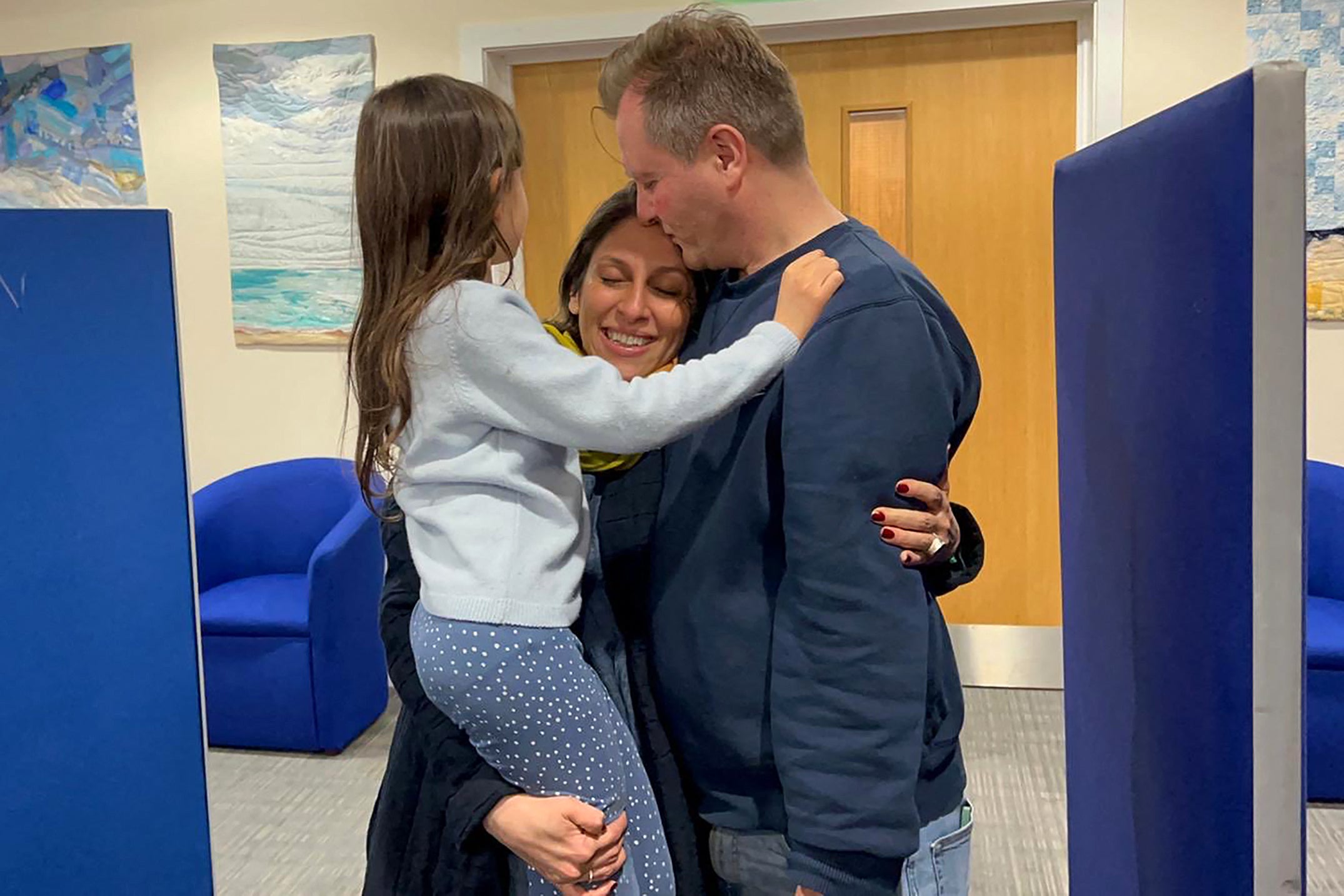 A handout picture released by the Free Nazanin campaign group shows Nazanin Zaghari-Ratcliffe hugging her husband Richard Ratcliffe and their daughter Gabriella upon her arrival