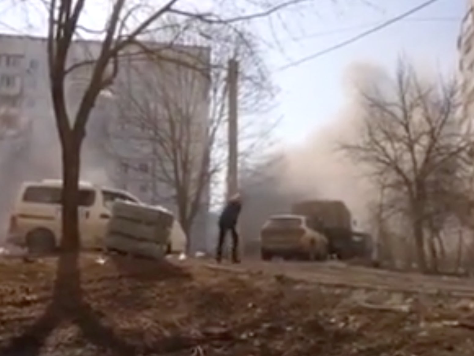 A man follows the group into the hollowed-out building following the sudden shelling