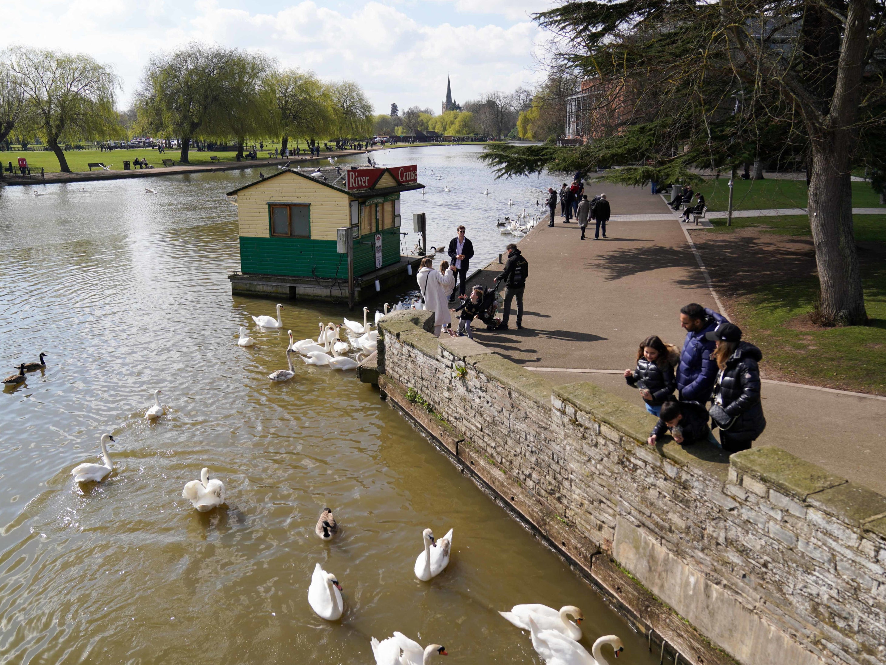 Families feed swans in Stratford-upon-Avon during warm weather on Sunday