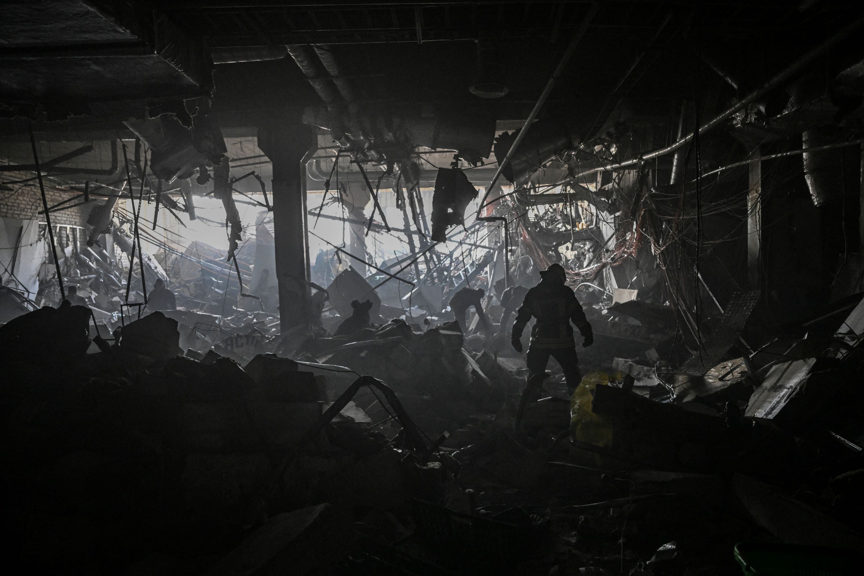 A Ukrainian serviceman walks between debris inside the Retroville shopping mall after a Russian attack on the northwest of the capital Kyiv on March 21, 2022