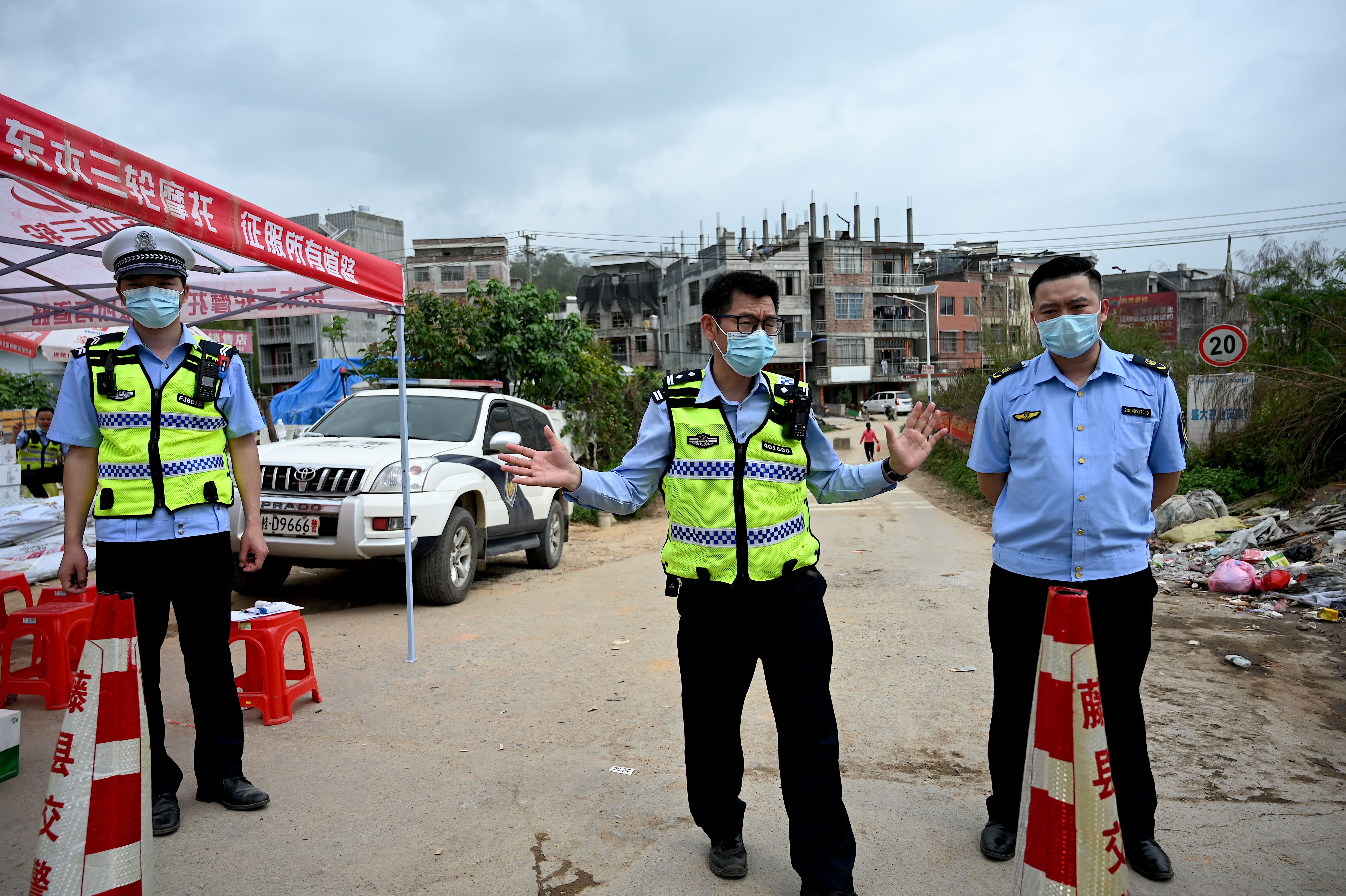 Policemen guard a checkpoint at Langnan village, in Wuzhou, near where the China Eastern flight crashed on 22 March