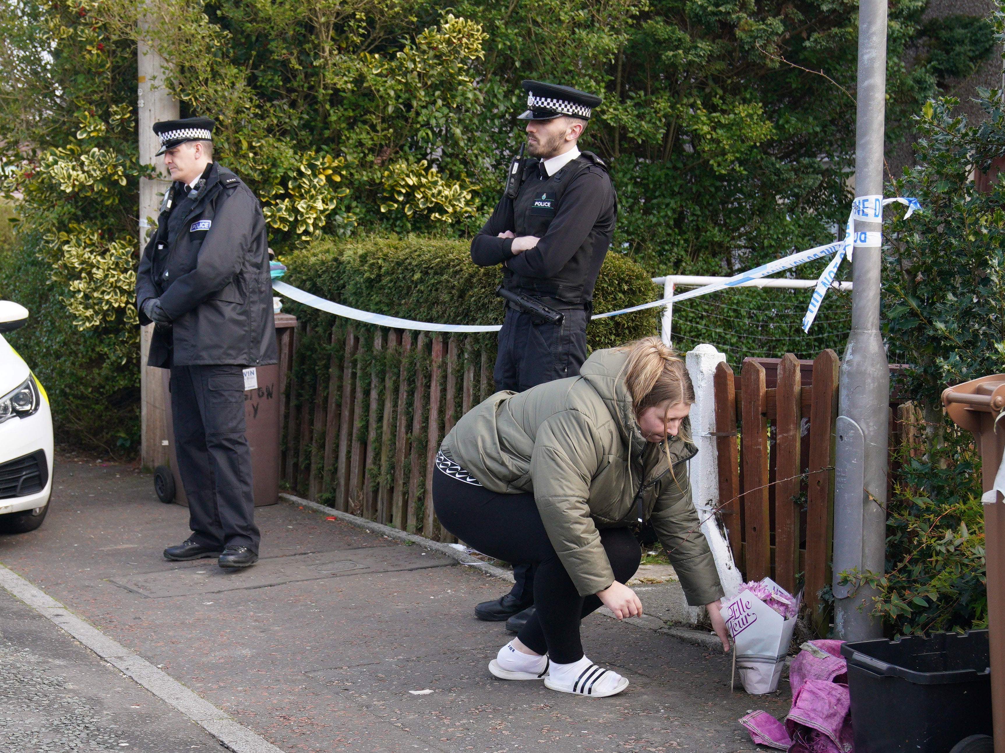 A woman lays flowers outside a house in St Helens as neighbours pay tribute to ‘beautiful’ Bella-Rae Birch who was killed in a dog attack inside the property