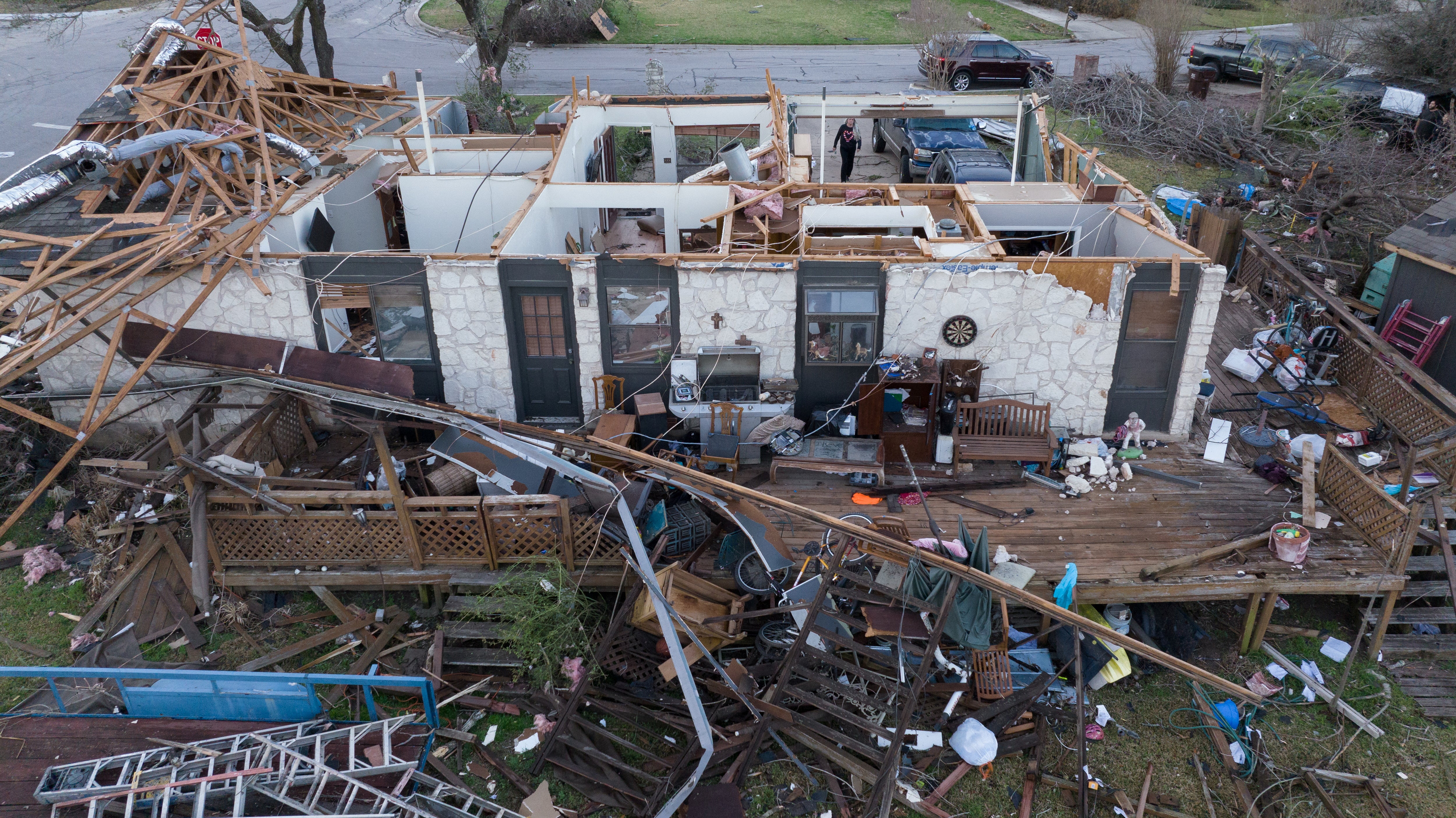 A woman walks through the garage of a destroyed home in the aftermath of a tornado in Round Rock on Tuesday