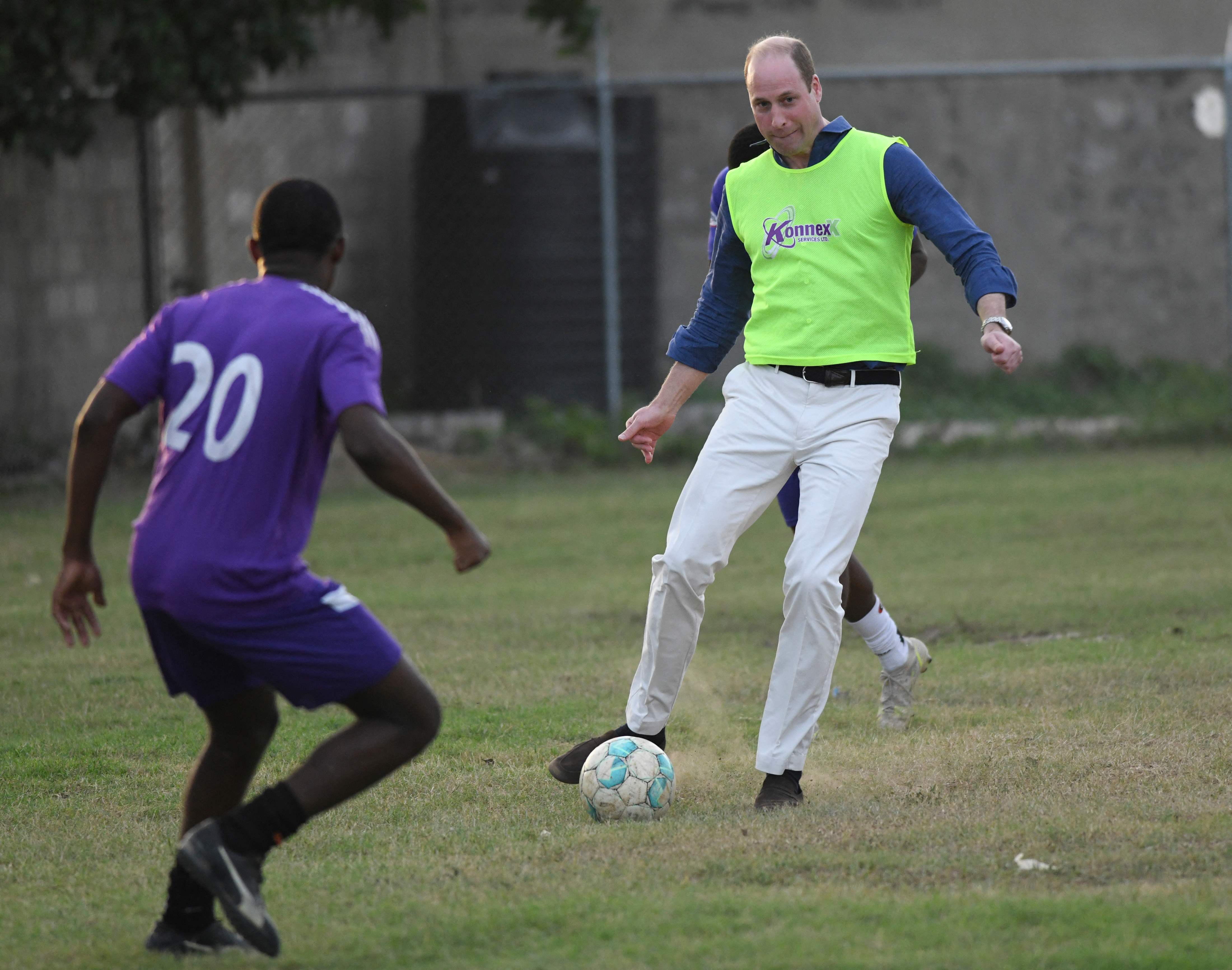 Prince William, Duke of Cambridge, (R) plays football with football players from Kingston College, winners of the ISSA Manning Cup Football competition