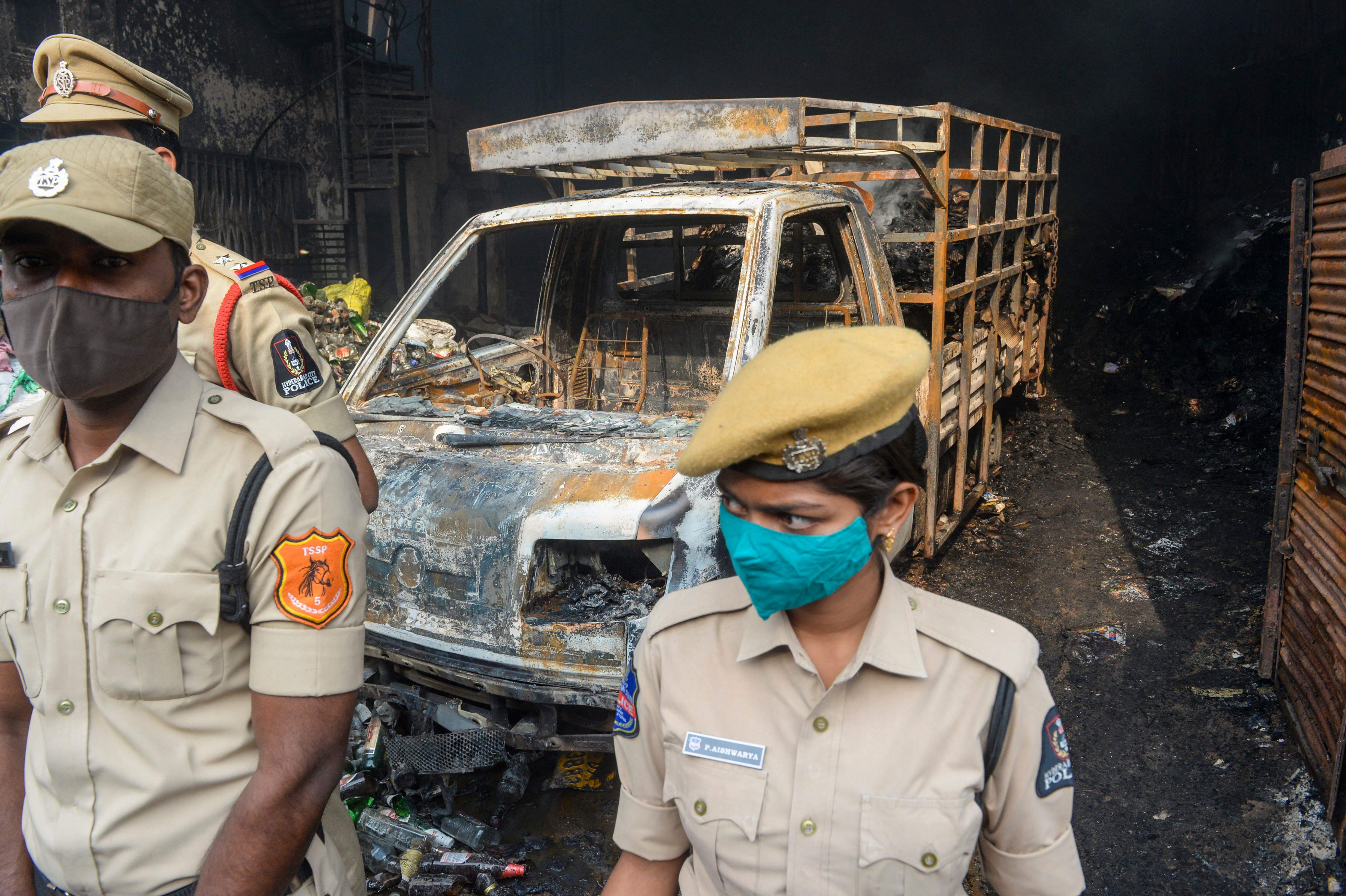 Police stand guard outside a warehouse after a fire broke out in Secunderabad