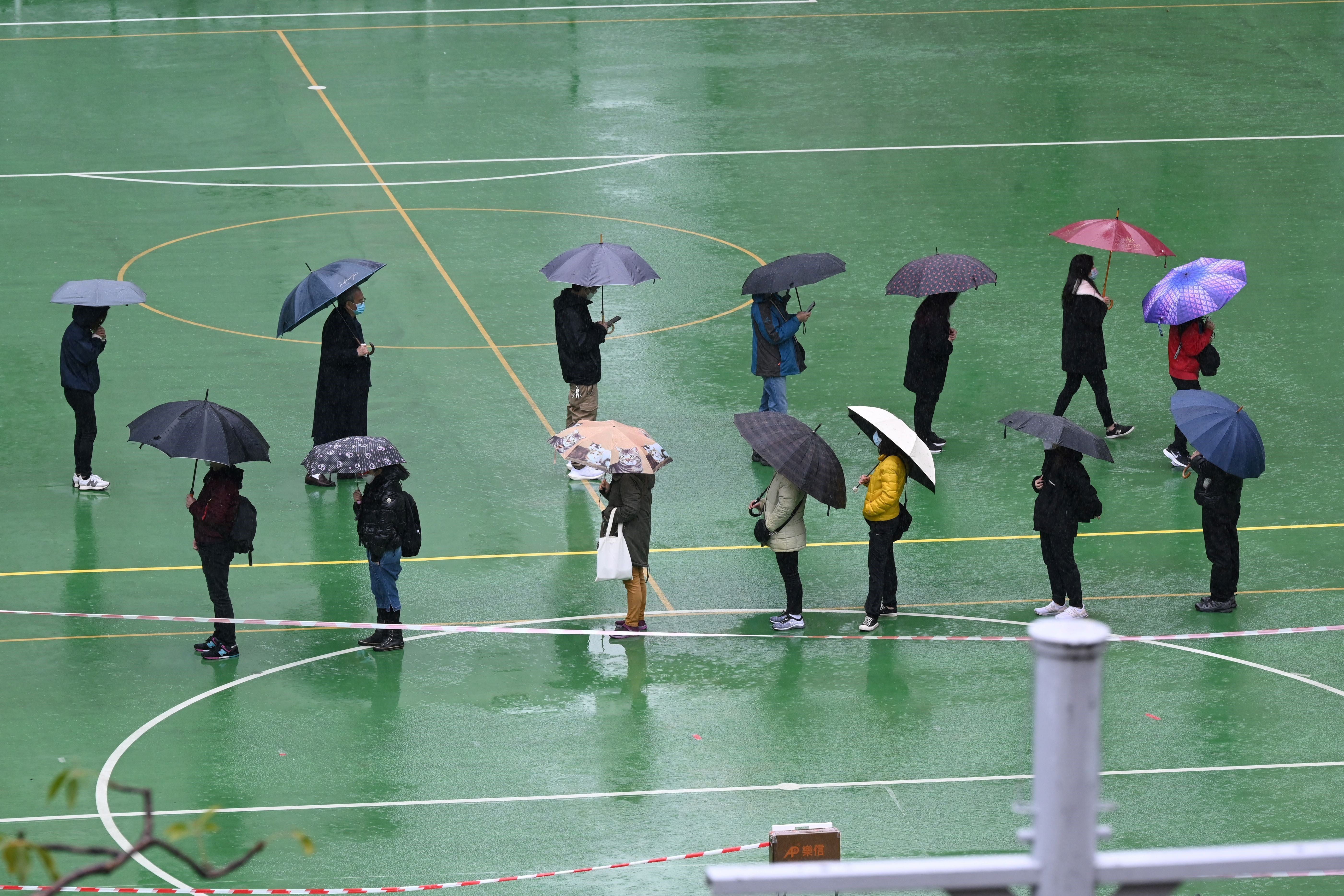 People queue for Covid tests in the pouring rain in Hong Kong, 22 February 2022