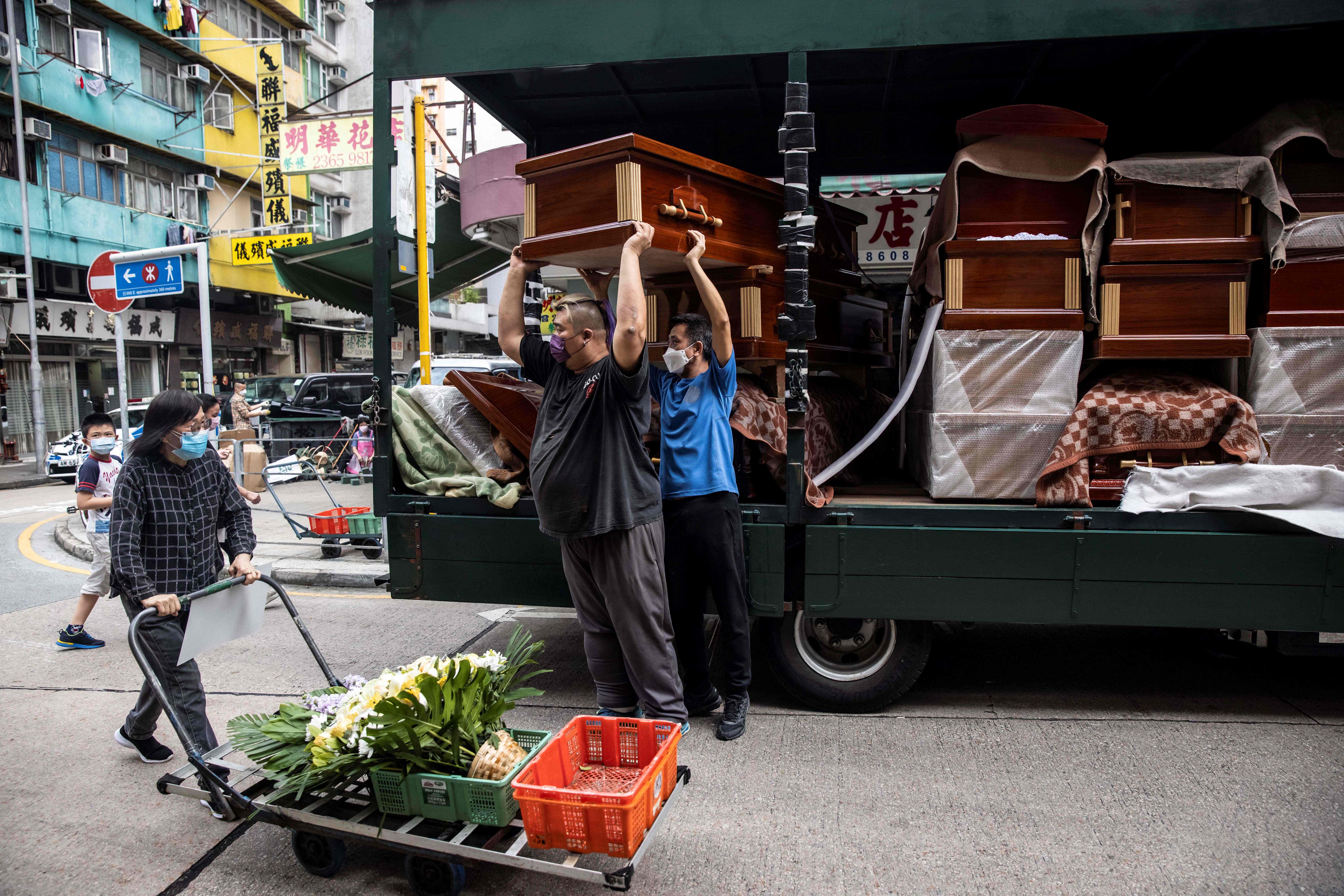 Empty coffins are delivered to a funeral services shop and funeral parlours in the Kowloon district of Hong Kong, 17 March 2022